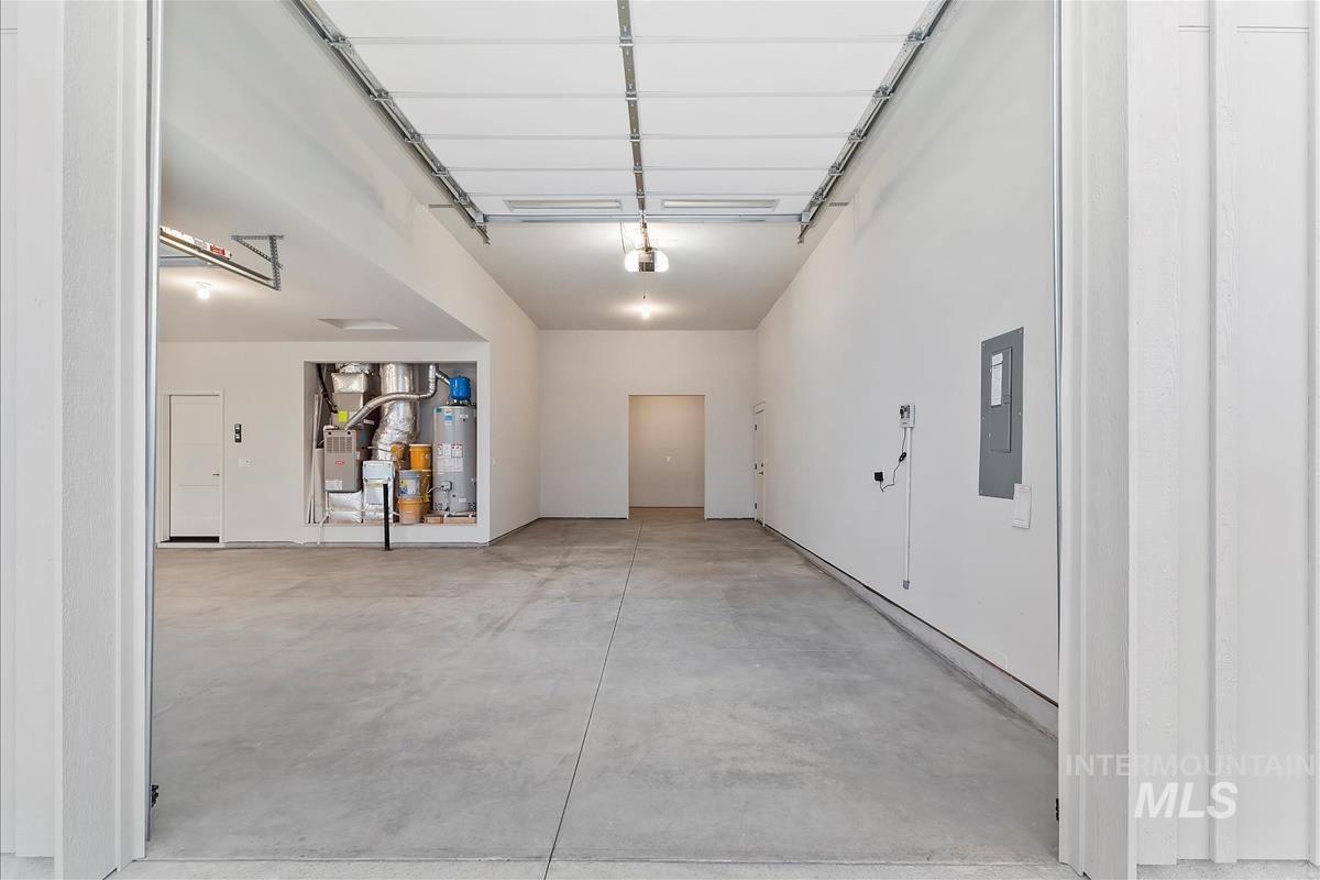 Garage featuring electric panel and water heater