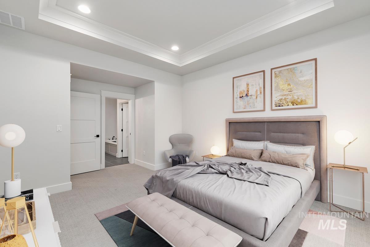 Carpeted bedroom with recessed lighting, ornamental molding, and a tray ceiling