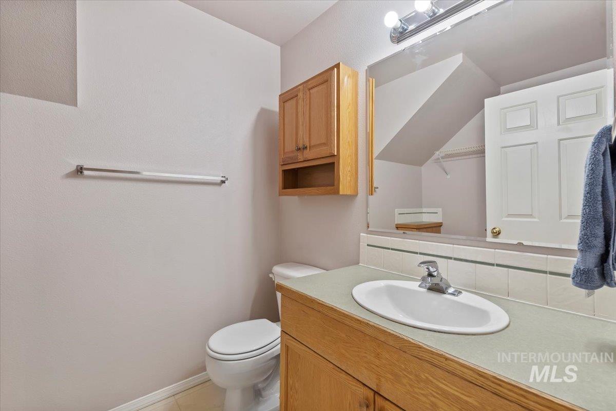 Bathroom featuring vanity, backsplash, and light tile patterned floors
