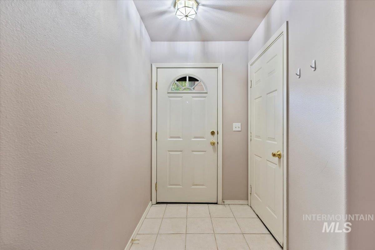 Entryway with tile patterned flooring and a textured wall