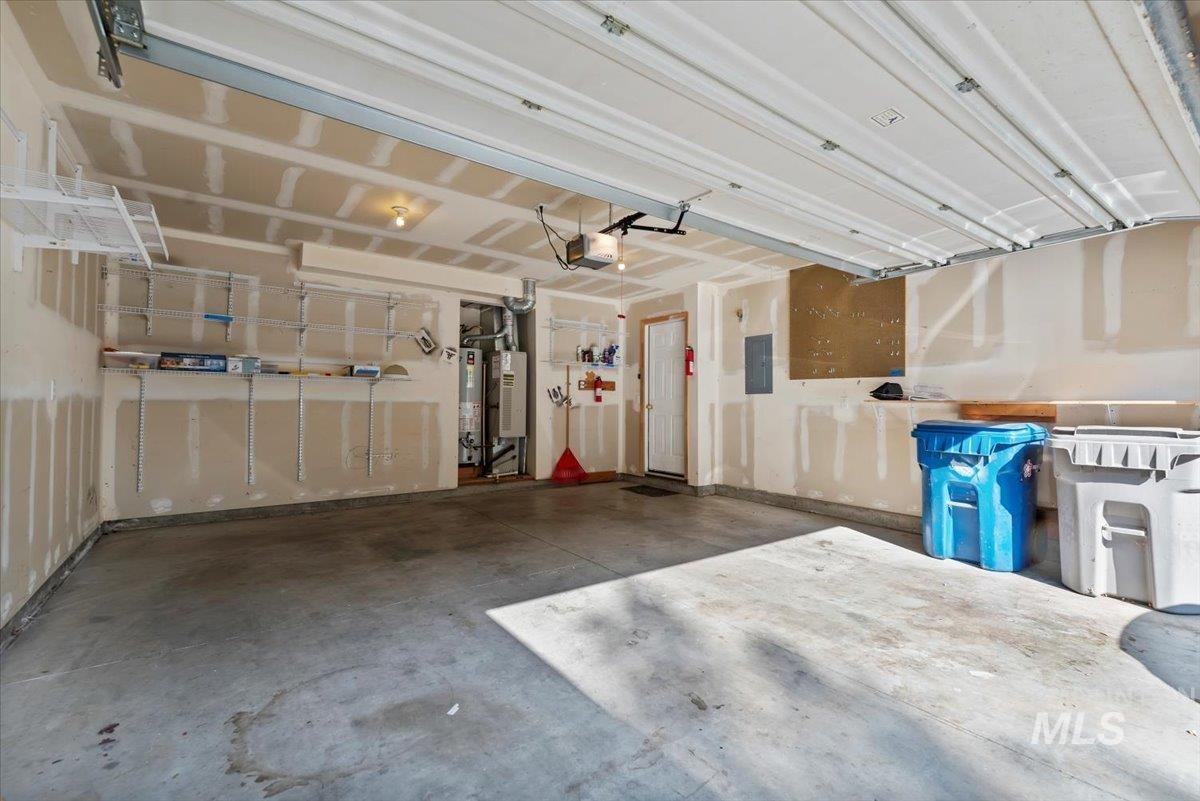 Garage featuring gas water heater and electric panel