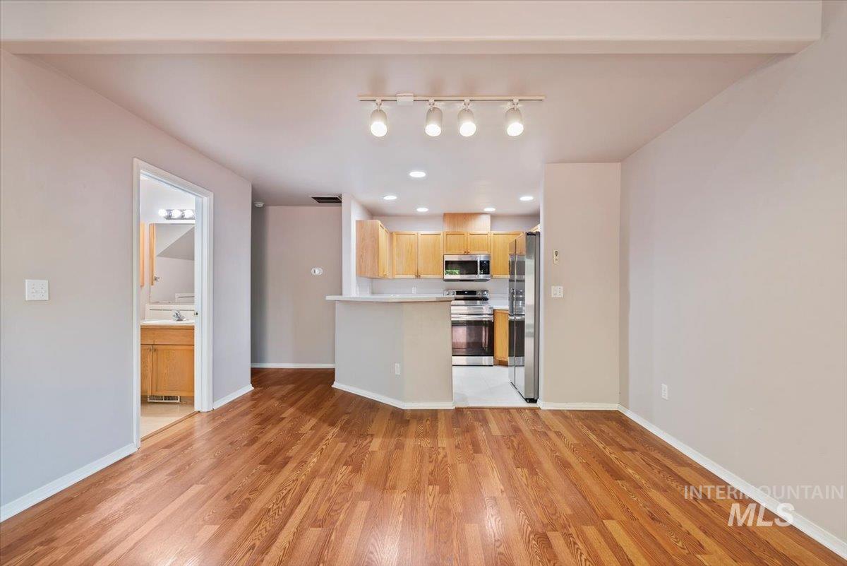 Kitchen with light countertops, stainless steel appliances, light brown cabinets, light wood finished floors, and recessed lighting