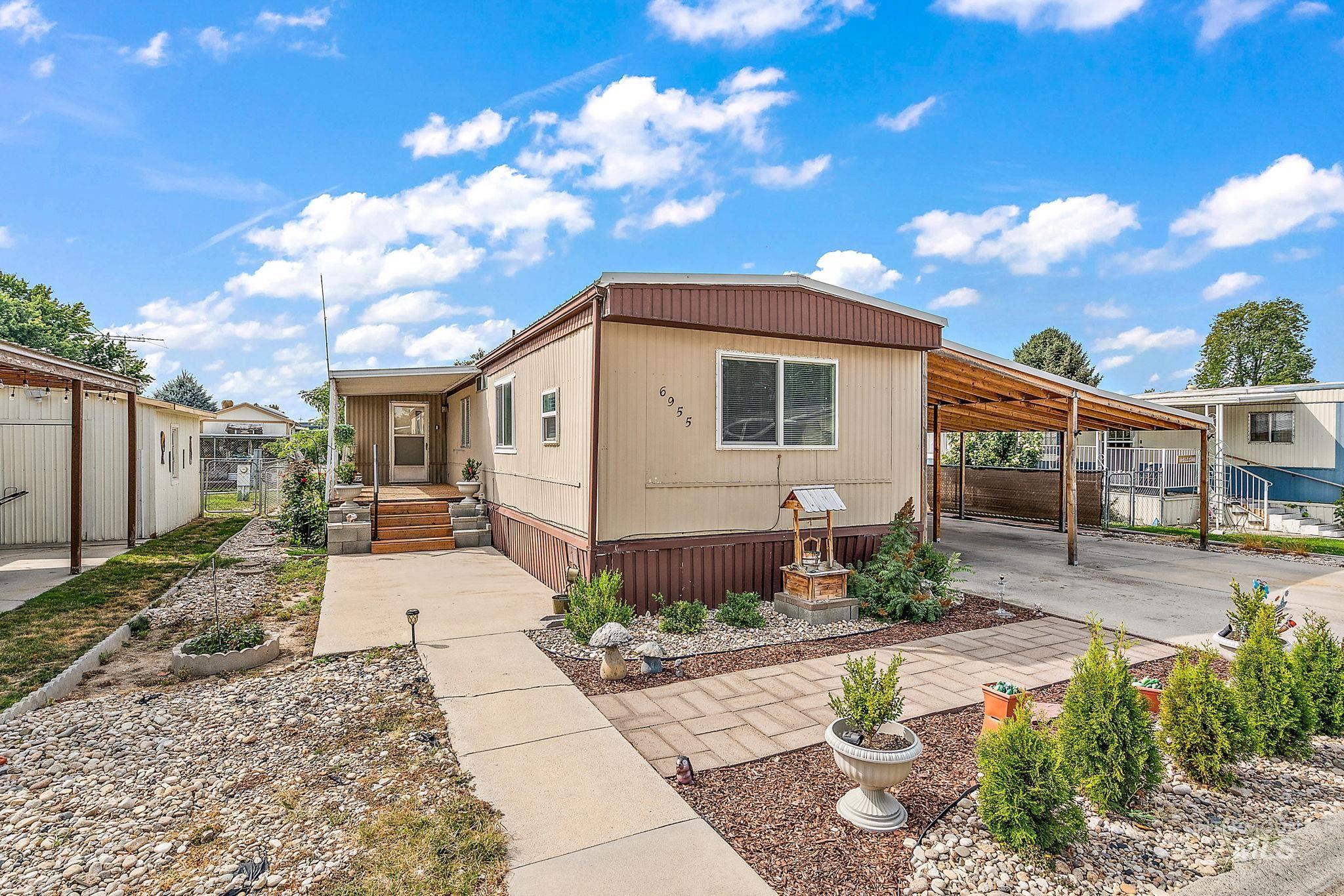 Manufactured / mobile home featuring a carport and driveway