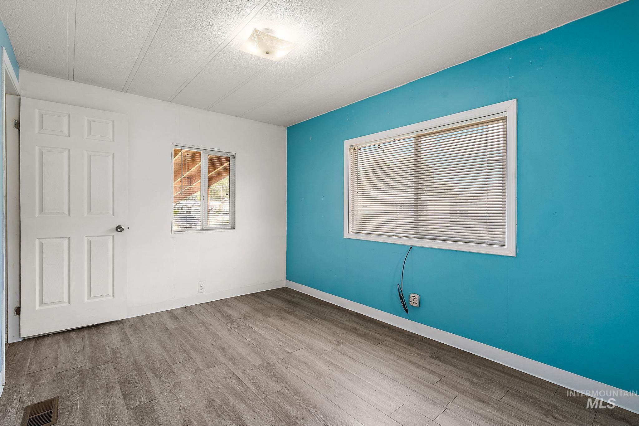 Spare room with light wood-type flooring and a textured ceiling