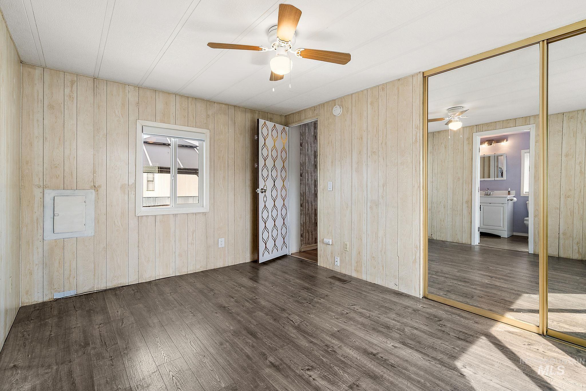 Master bedroom featuring wood finished floors, a closet, and wooden walls