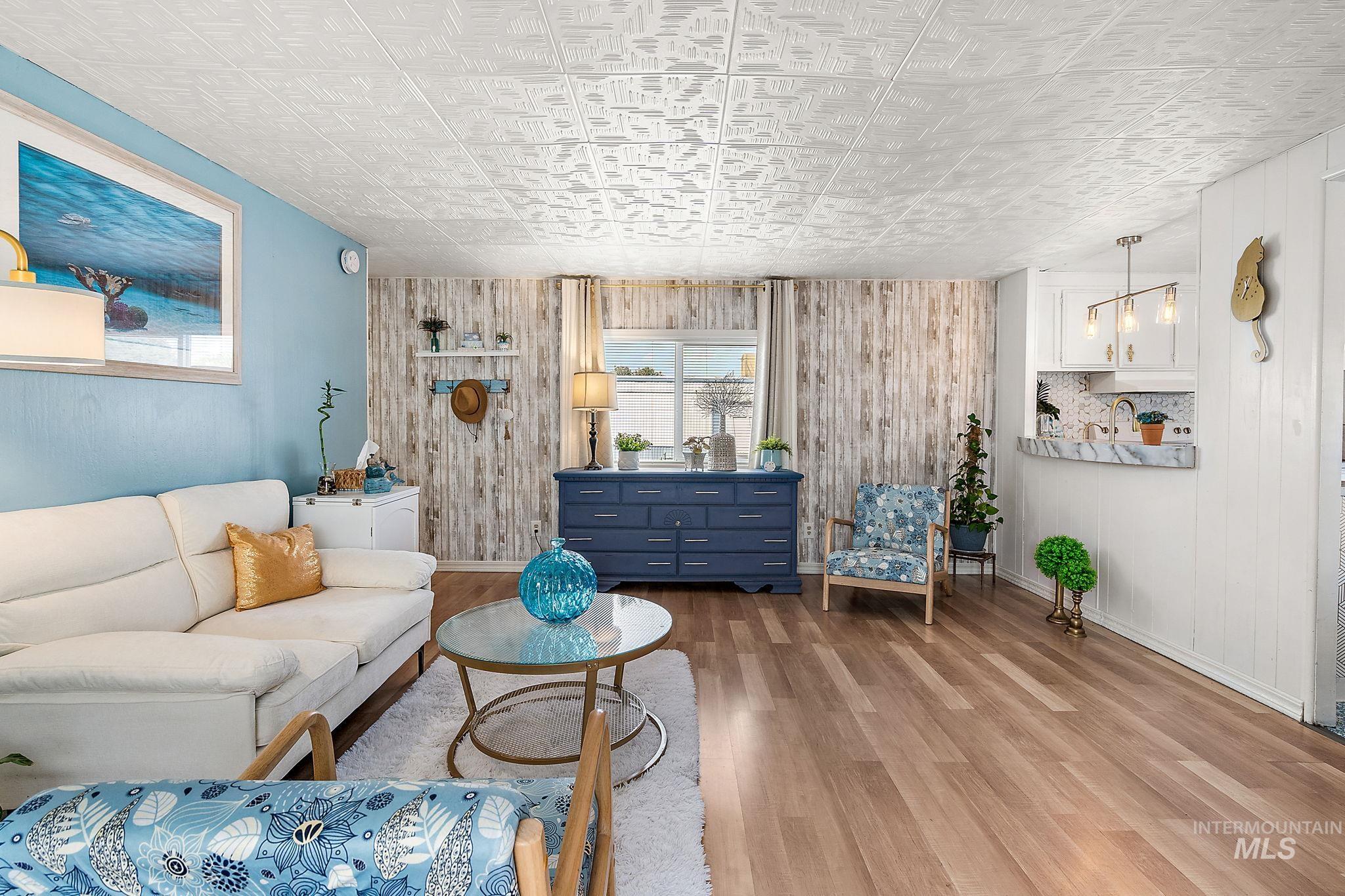 Living area with wood finished floors, an ornate ceiling, and wood walls