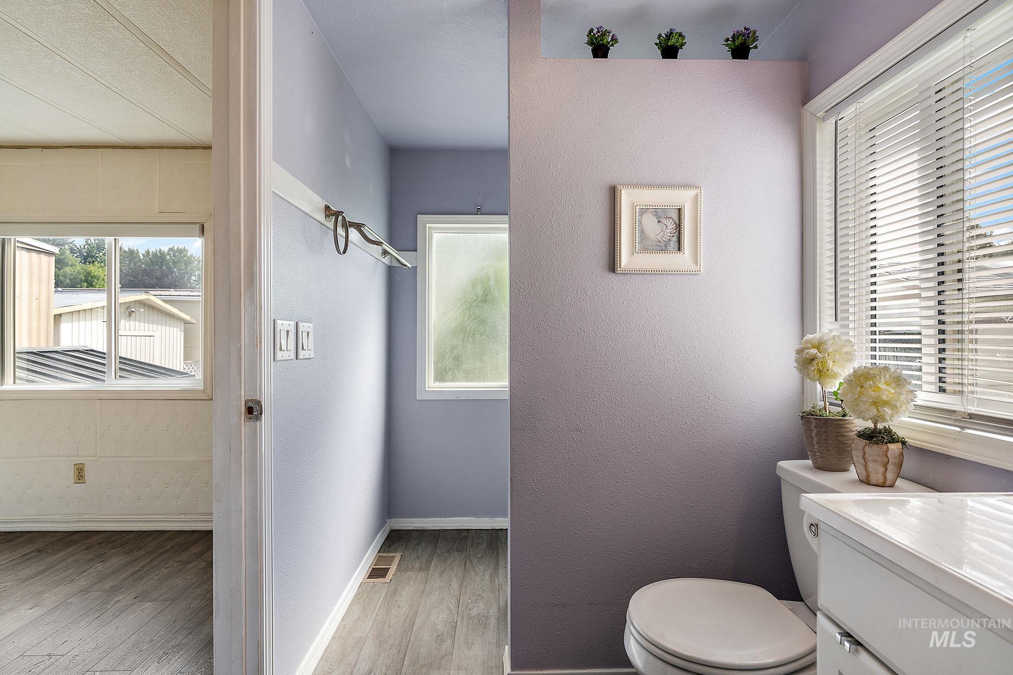 Master Bathroom with light wood-style floors, a textured wall, and vanity