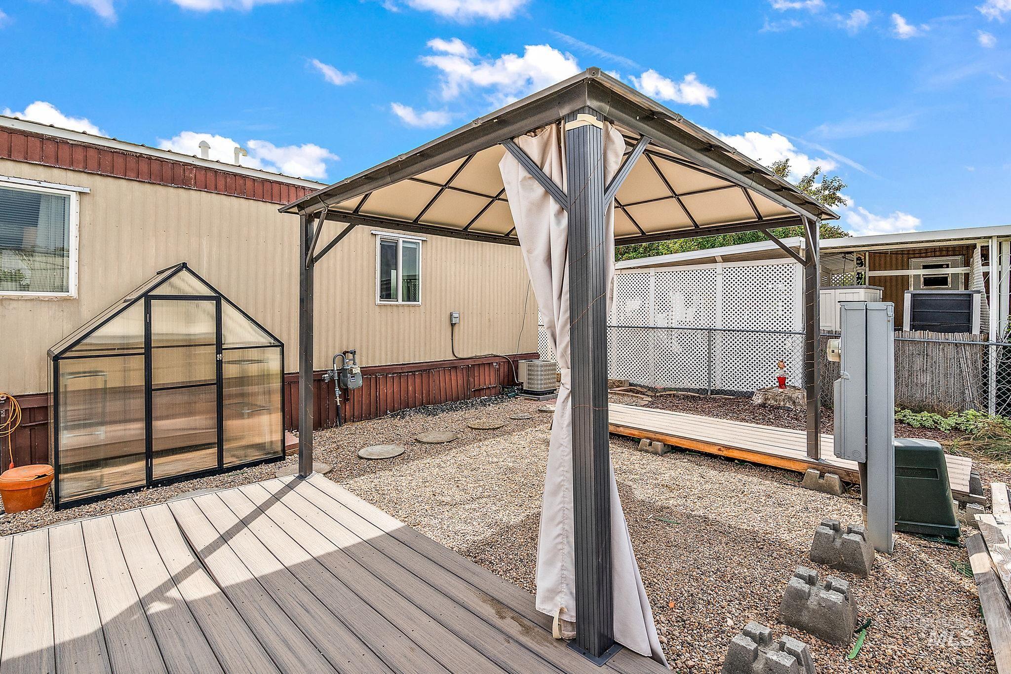 Wooden deck featuring an exterior structure, an outdoor structure, and a gazebo