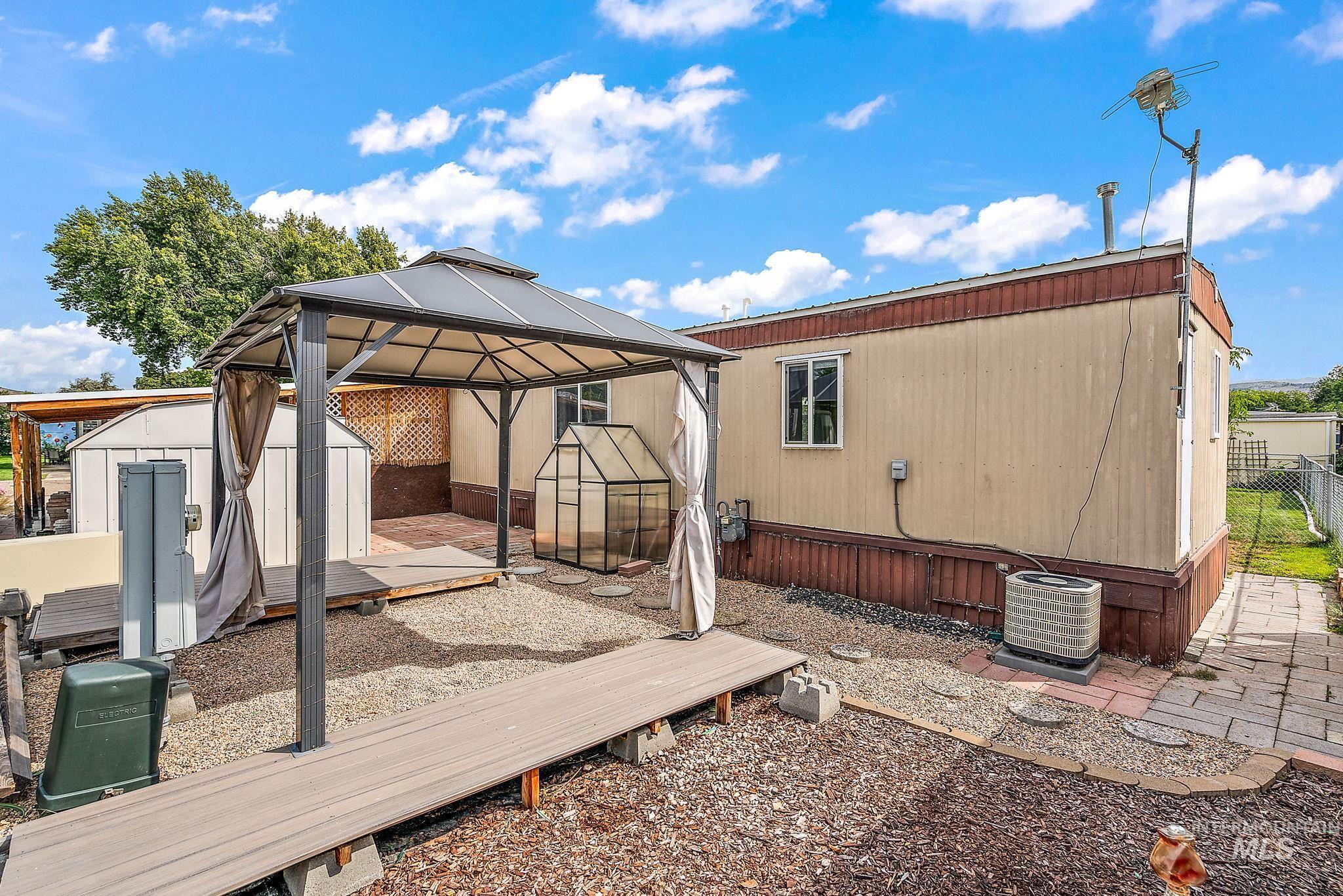 Rear view of house with a gazebo, a shed, a deck, and a patio area