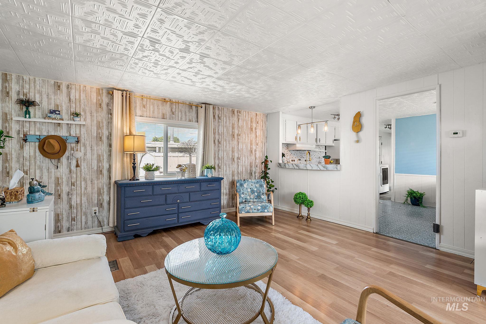 Living area with wood walls, wood finished floors, and an ornate ceiling