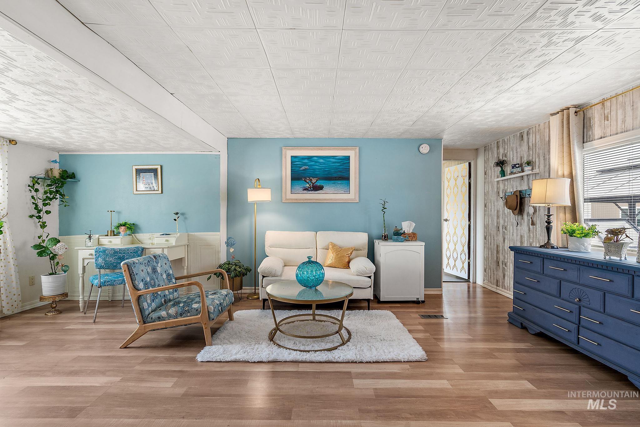 Sitting room with light wood-type flooring and wood walls