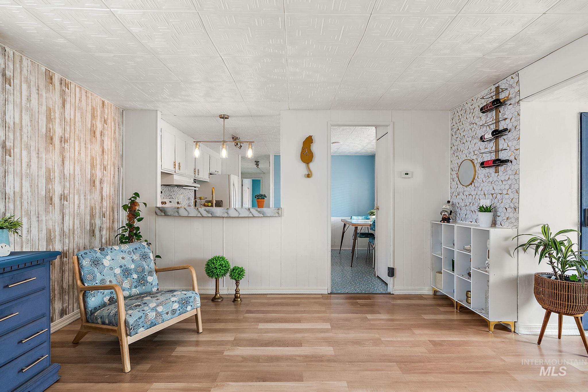 Sitting room featuring light wood-style flooring and wooden walls