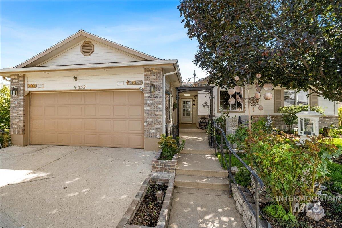 View of front of property featuring concrete driveway, an attached garage, and brick siding
