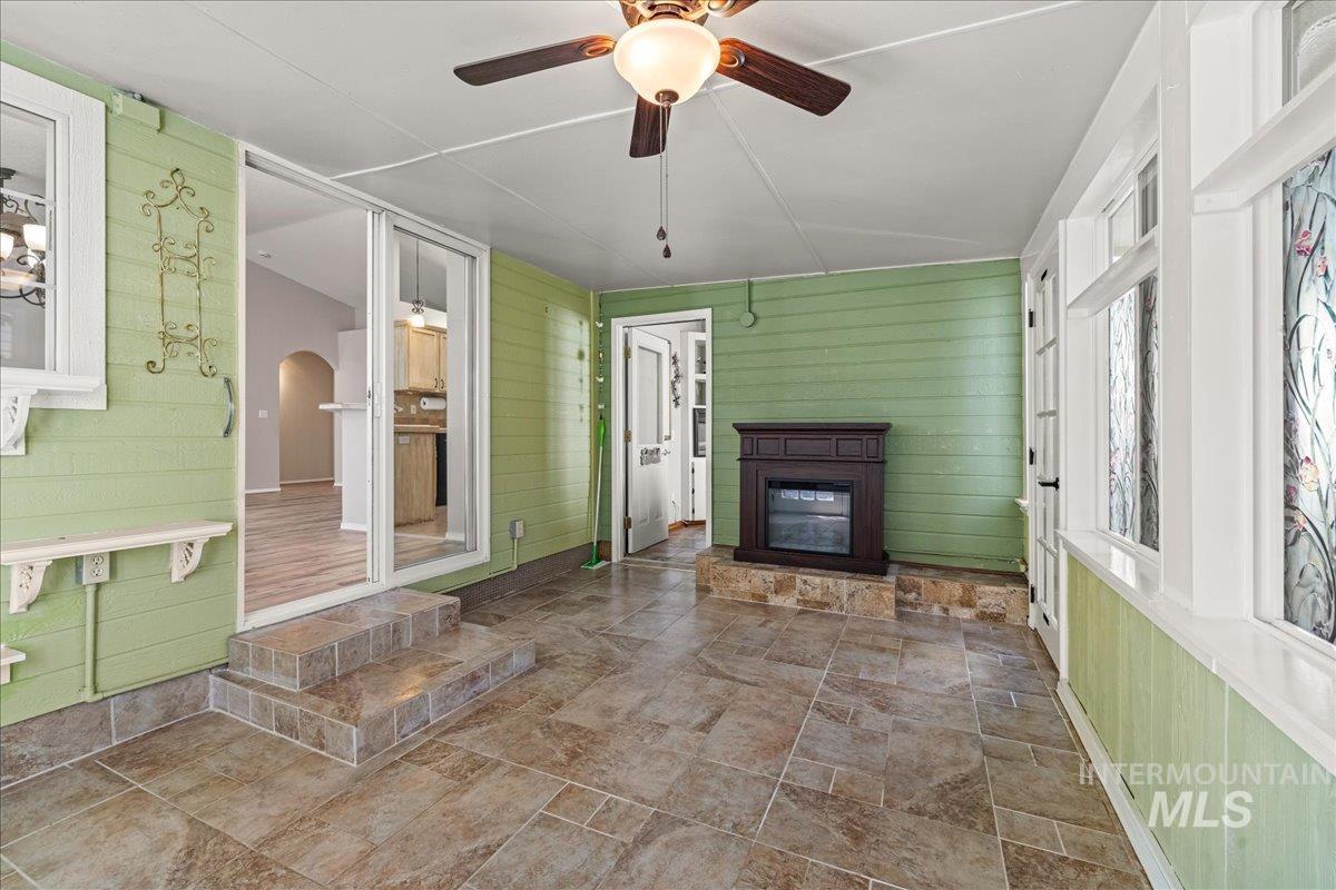 Unfurnished sunroom with arched walkways and lofted ceiling