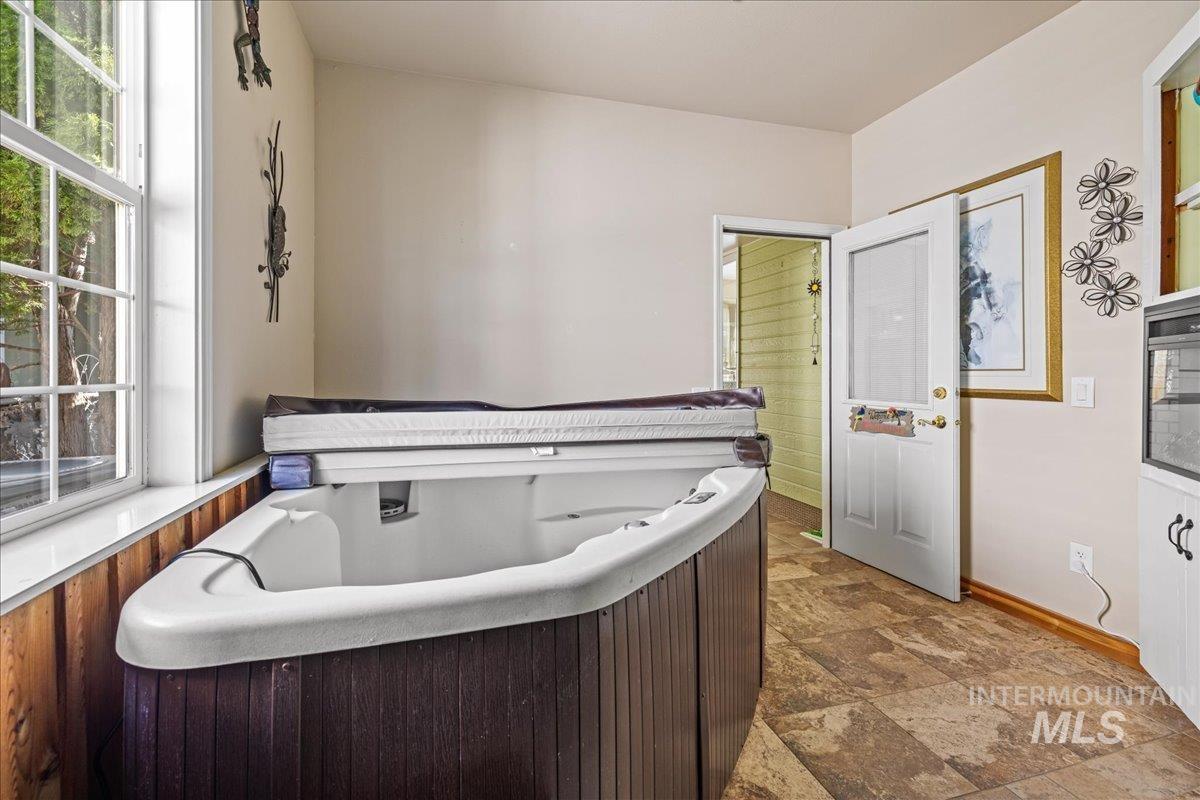 Bathroom with a jetted tub and stone finish flooring