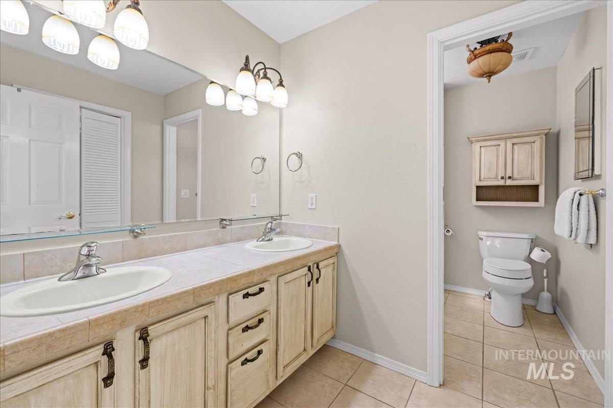 Bathroom featuring light tile patterned flooring and double vanity