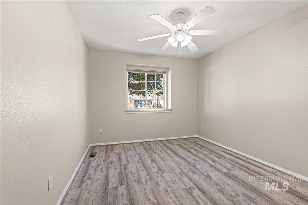 Unfurnished room featuring wood finished floors and ceiling fan