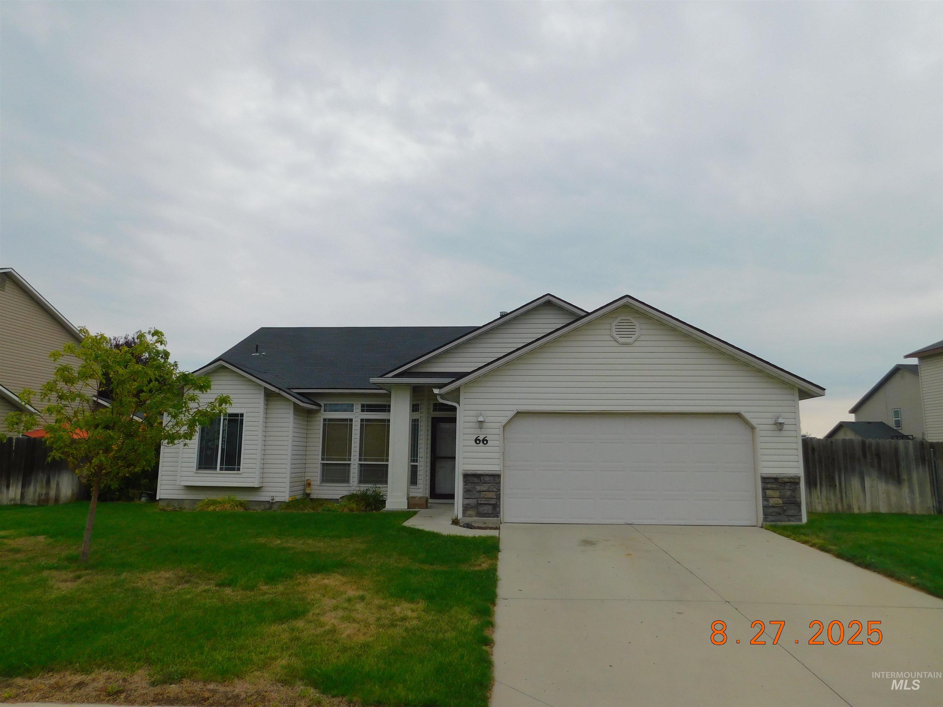Ranch-style house with stone siding, concrete driveway, and an attached garage