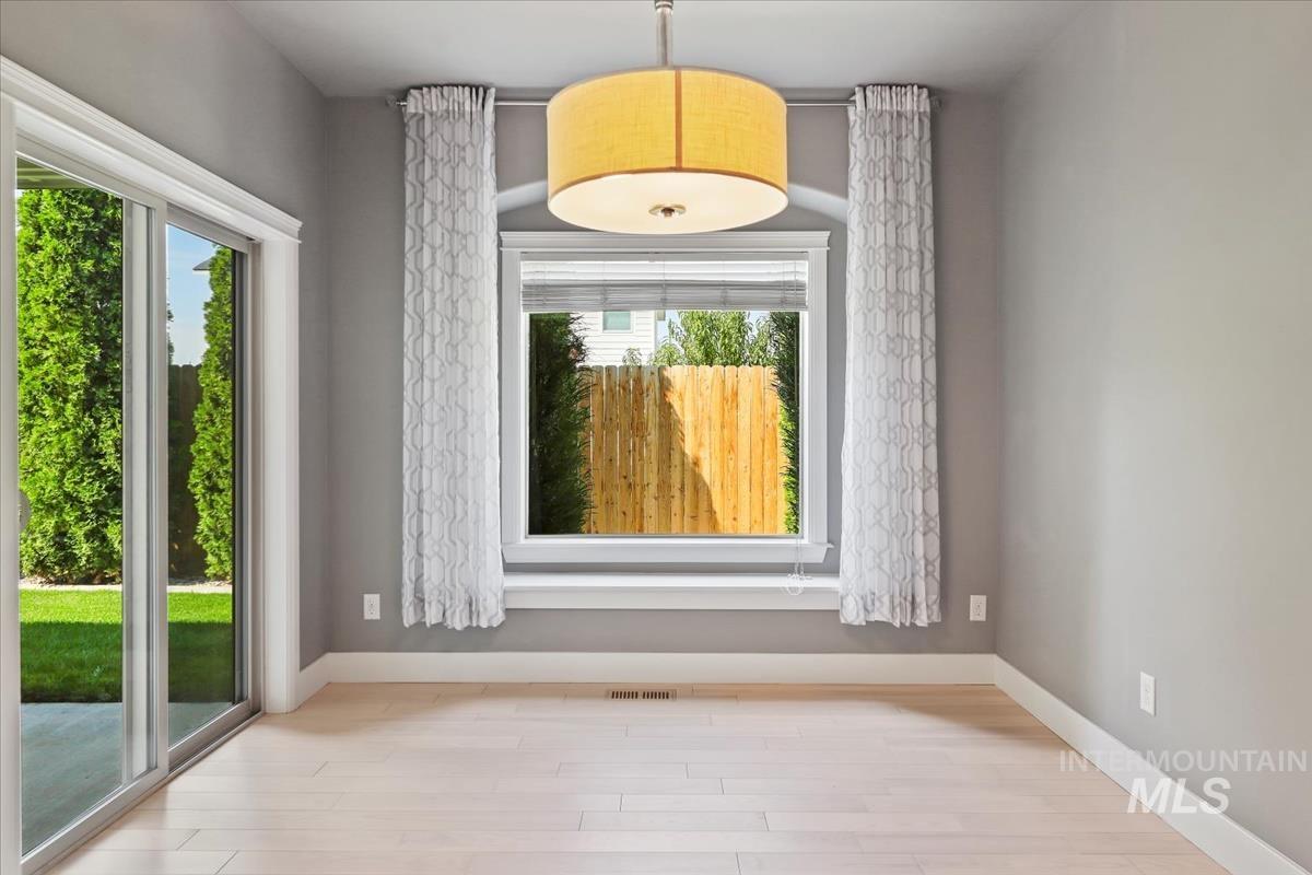 Unfurnished dining area featuring baseboards and wood finished floors