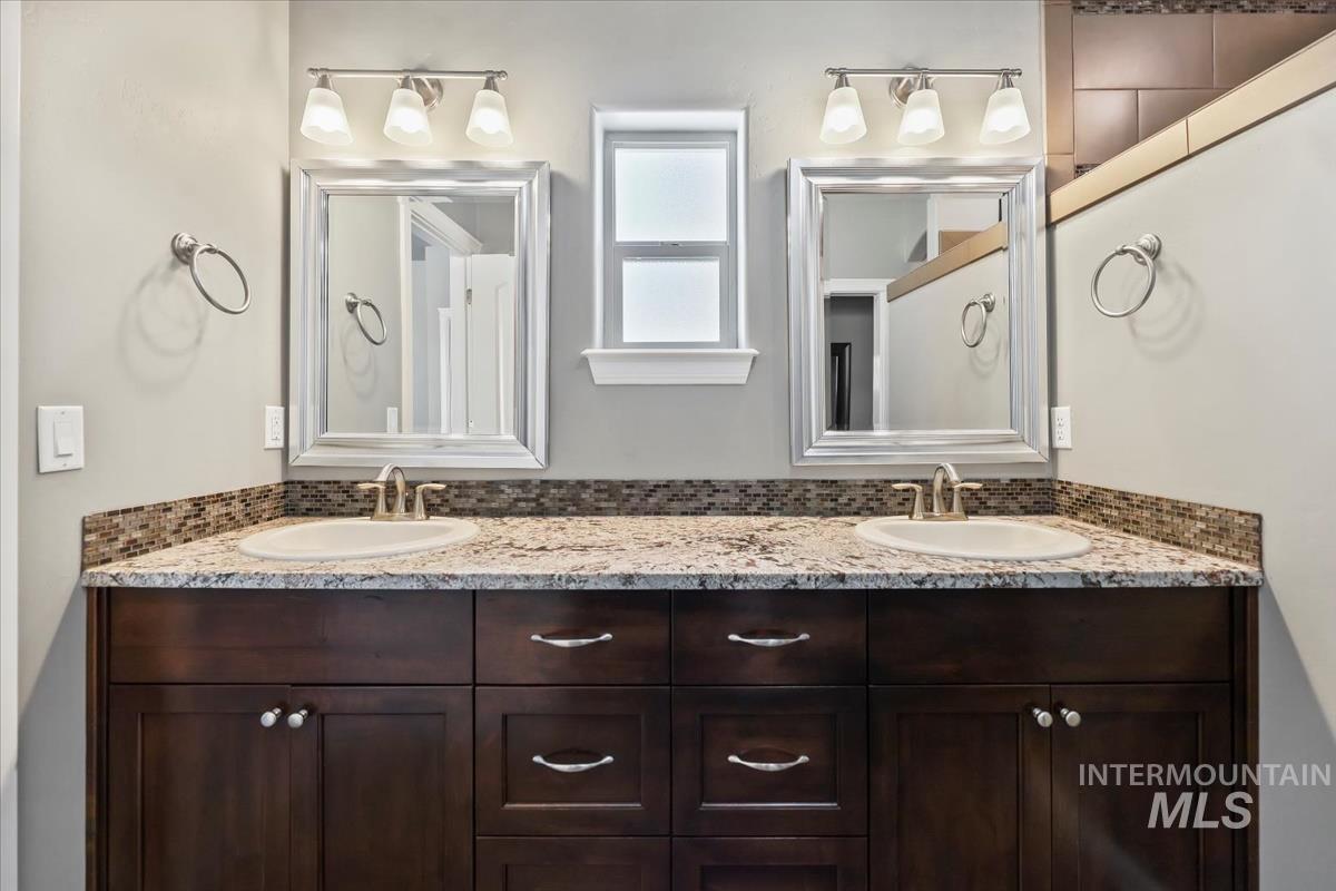 Full bathroom with double vanity and backsplash