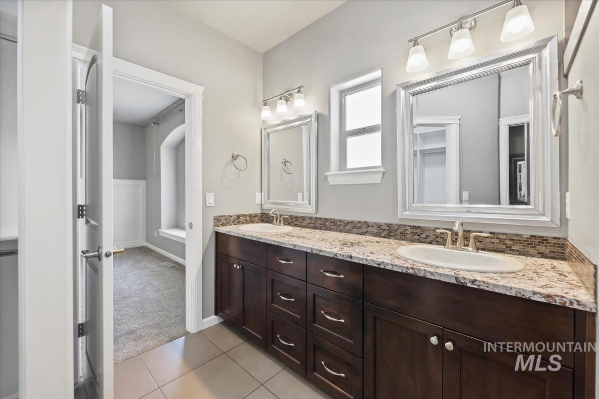 Full bathroom with double vanity and light tile patterned flooring