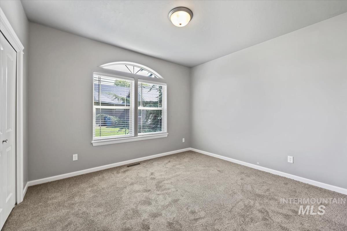 Carpeted spare room with baseboards