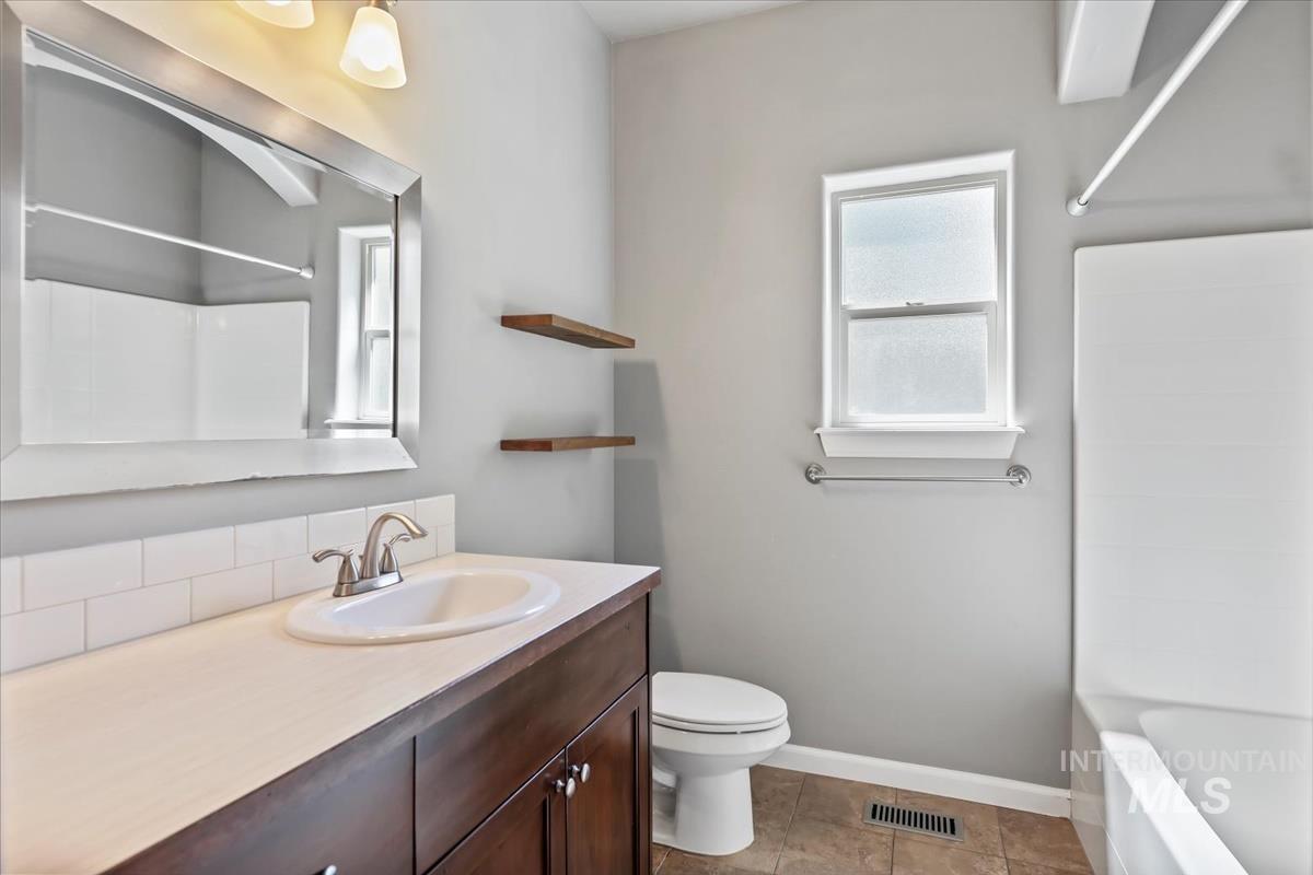 Full bathroom featuring vanity, washtub / shower combination, and light tile patterned flooring