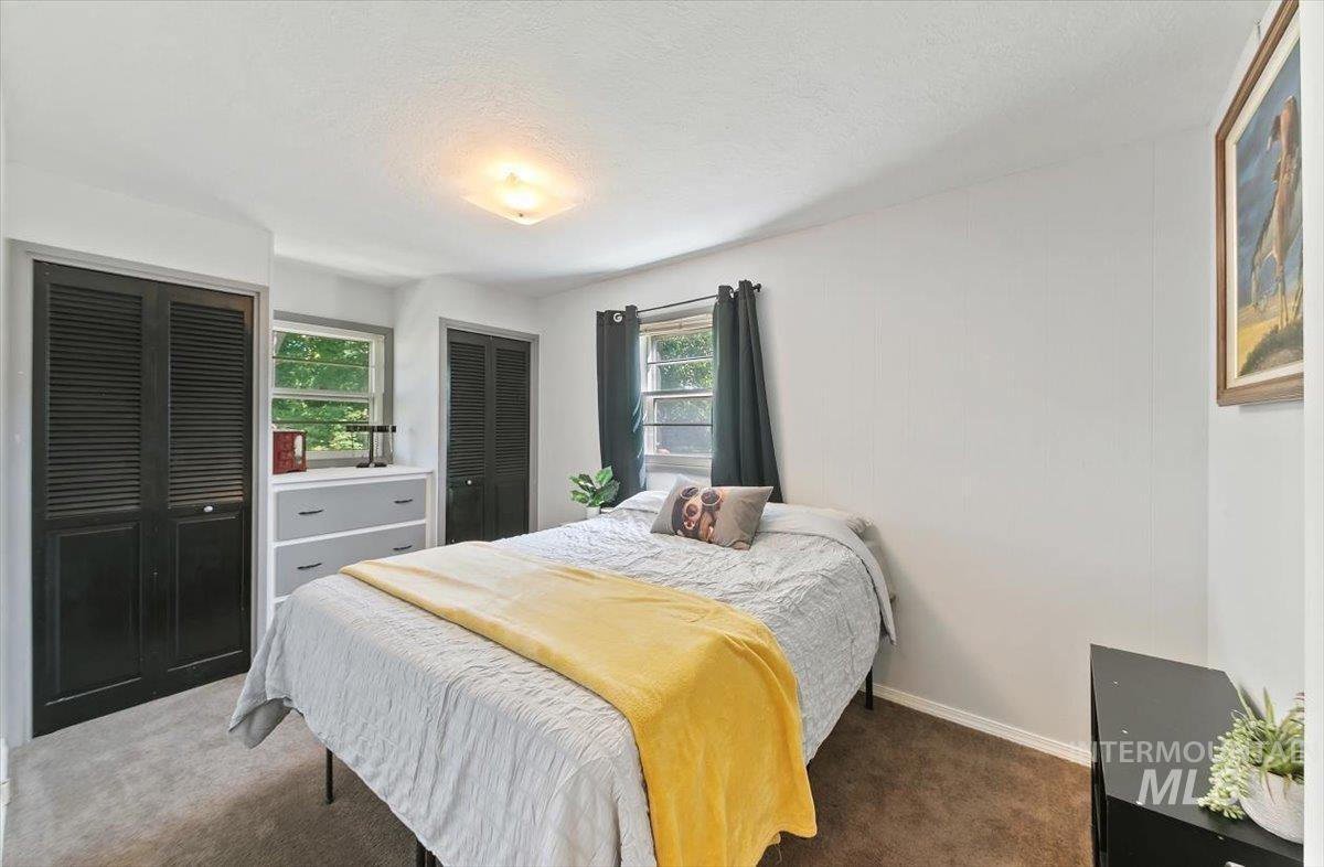Bedroom featuring carpet, two closets, and a textured ceiling