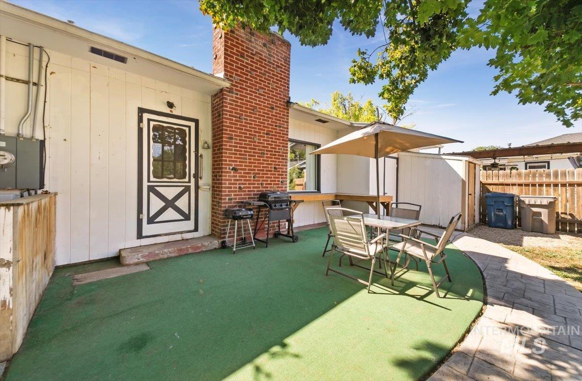 View of patio featuring a grill, outdoor dining area, and an outdoor structure