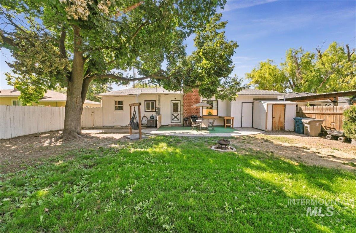Rear view of house with a patio, a storage shed, and stucco siding