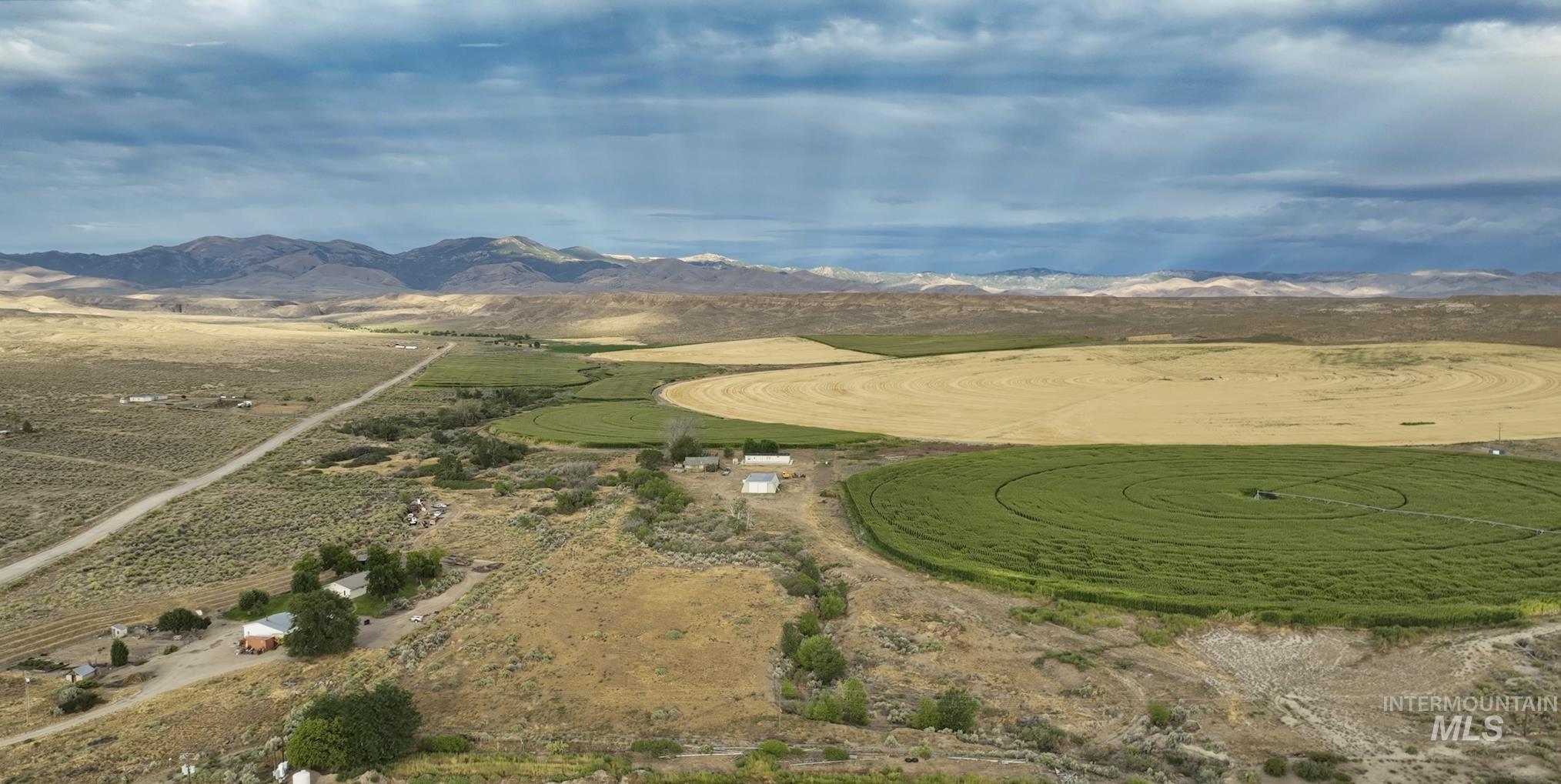 Aerial overview of property's location with a mountain backdrop and rural landscape