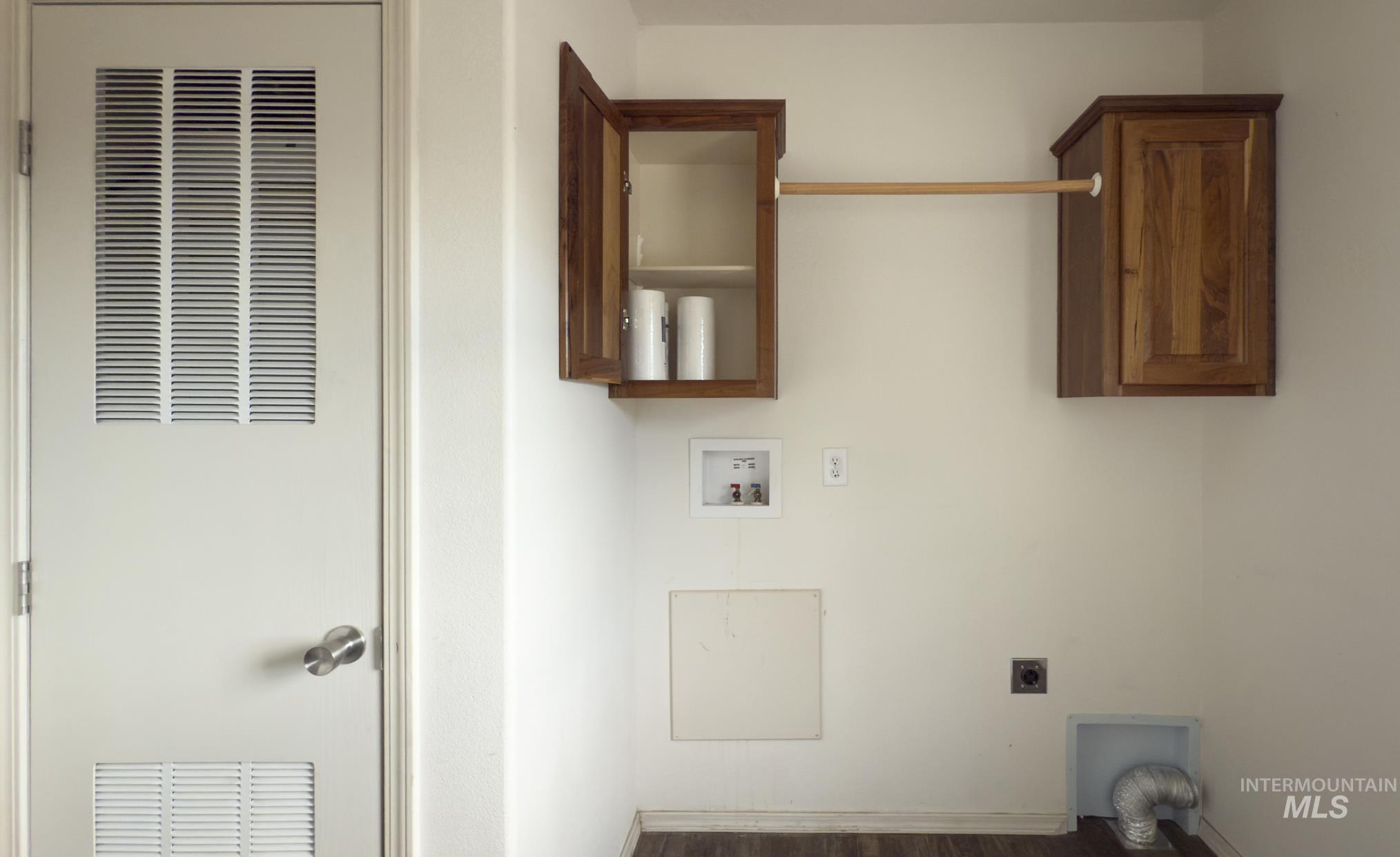 Laundry room featuring a heating unit, wood finished floors, electric dryer hookup, and washer hookup