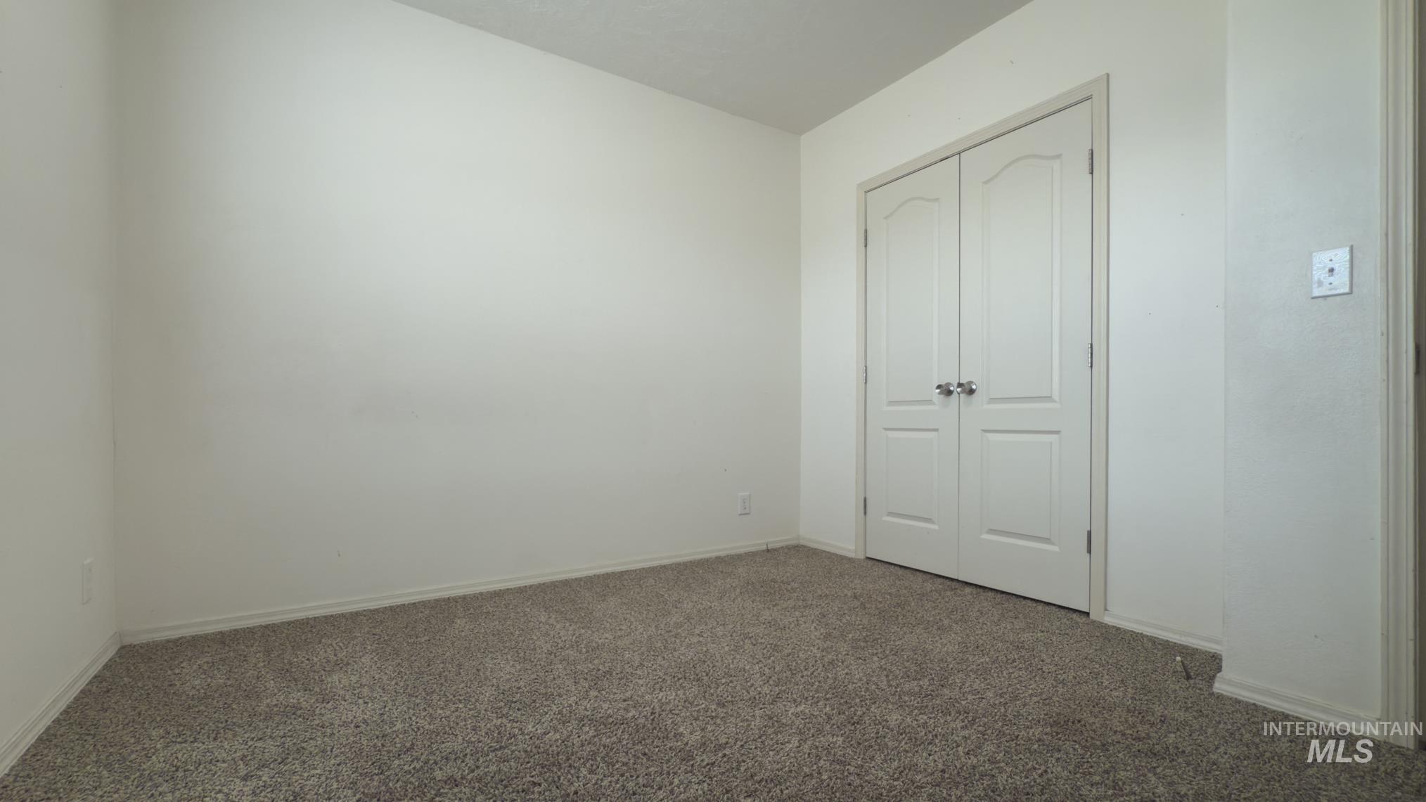 Unfurnished bedroom with carpet flooring and a closet