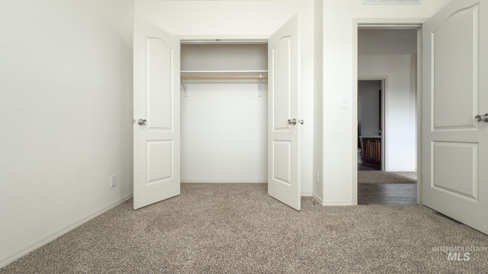 Unfurnished bedroom featuring light carpet and a closet