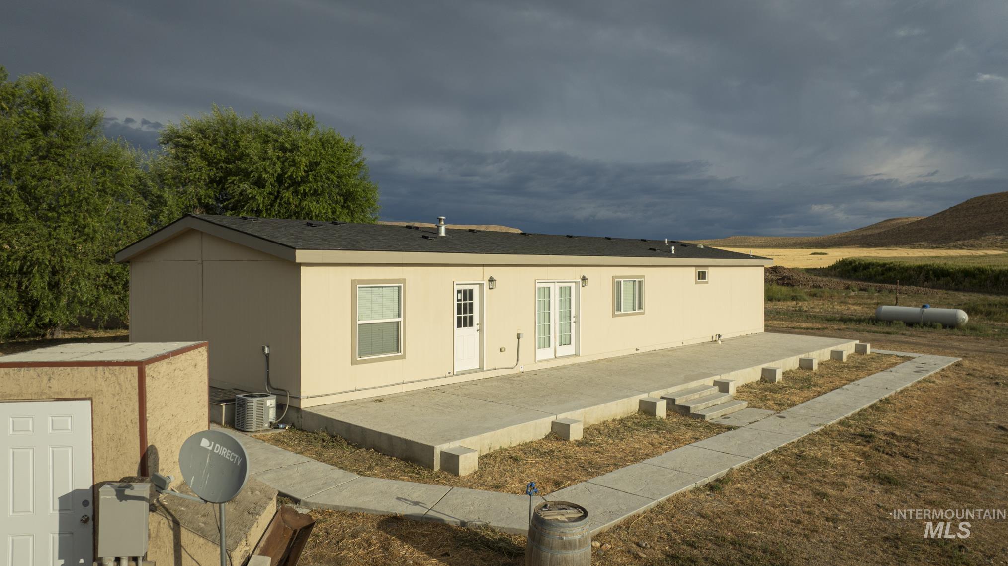 Rear view of house featuring a patio and roof with shingles