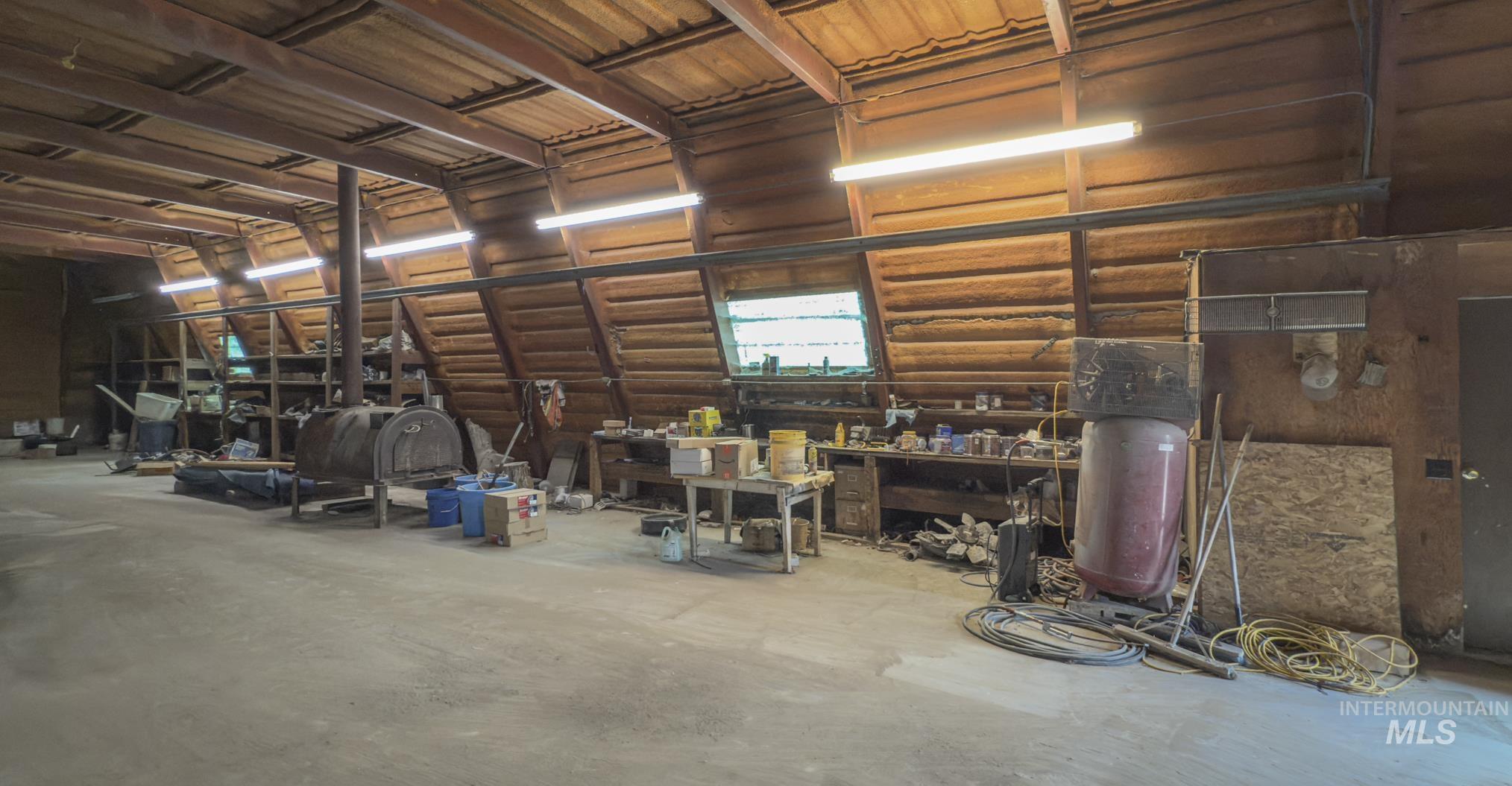 Miscellaneous room featuring a workshop area, a garage, and concrete floors