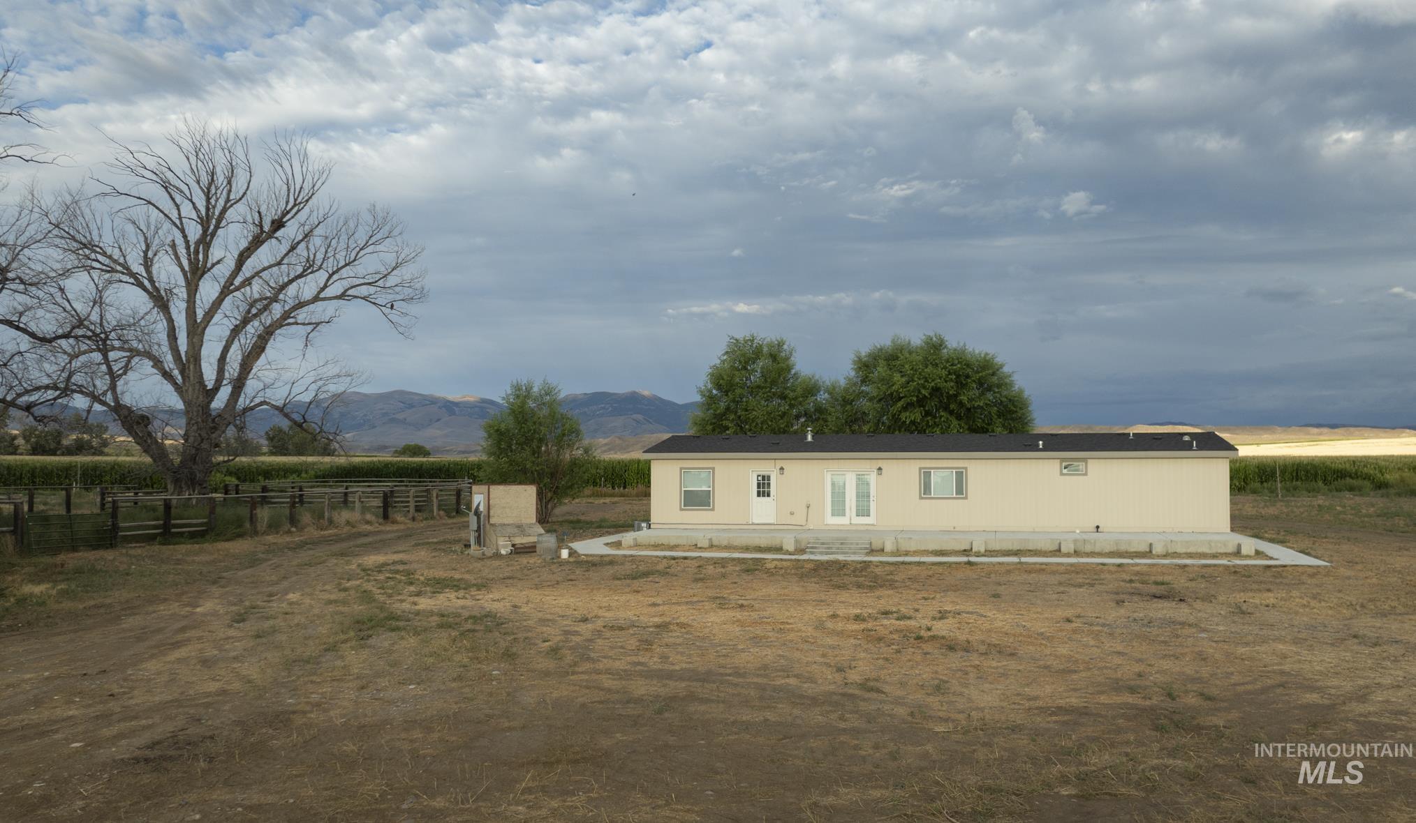 View of front of property featuring a mountain view, a rural view, and a patio
