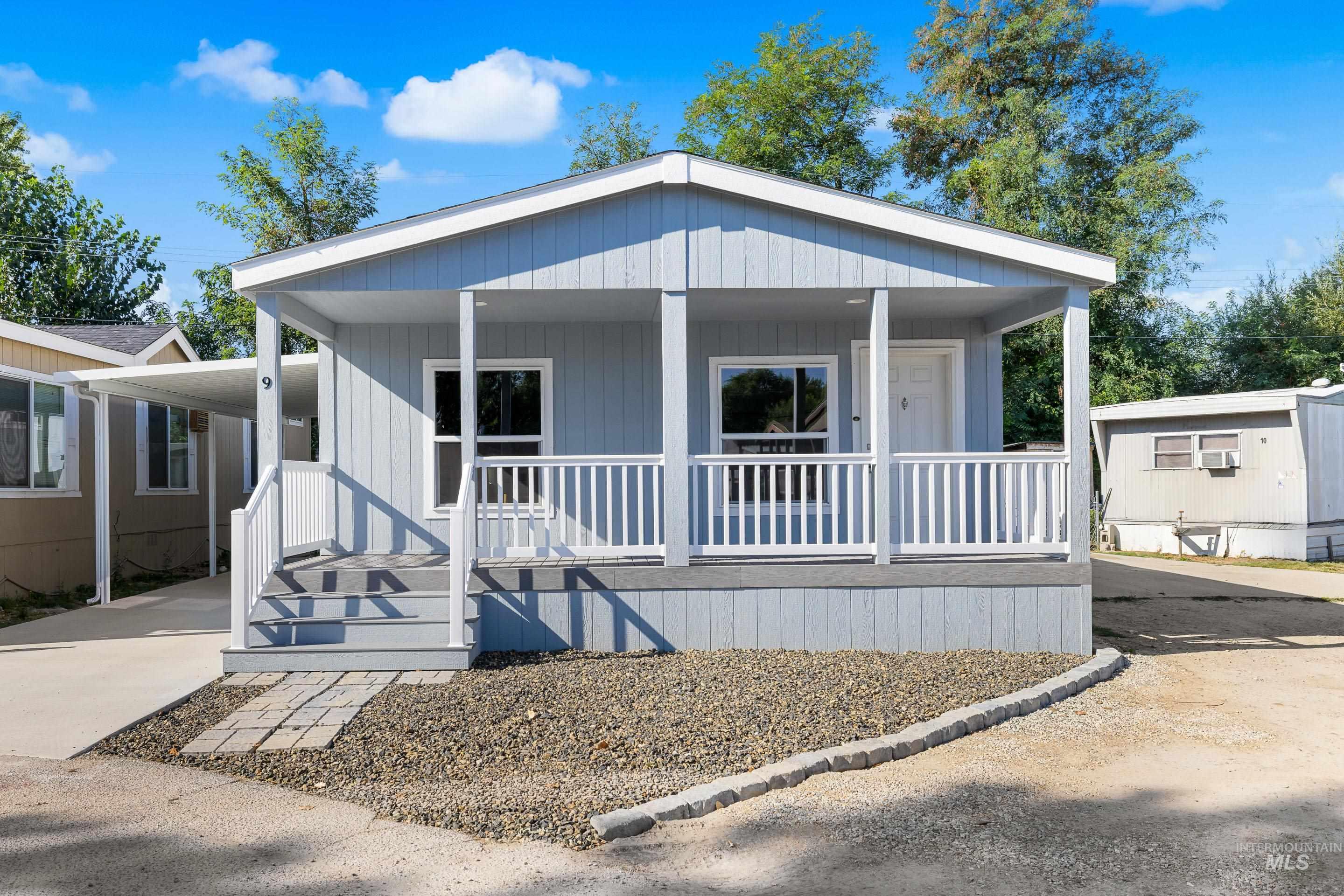 Manufactured / mobile home with covered porch, driveway, and a carport