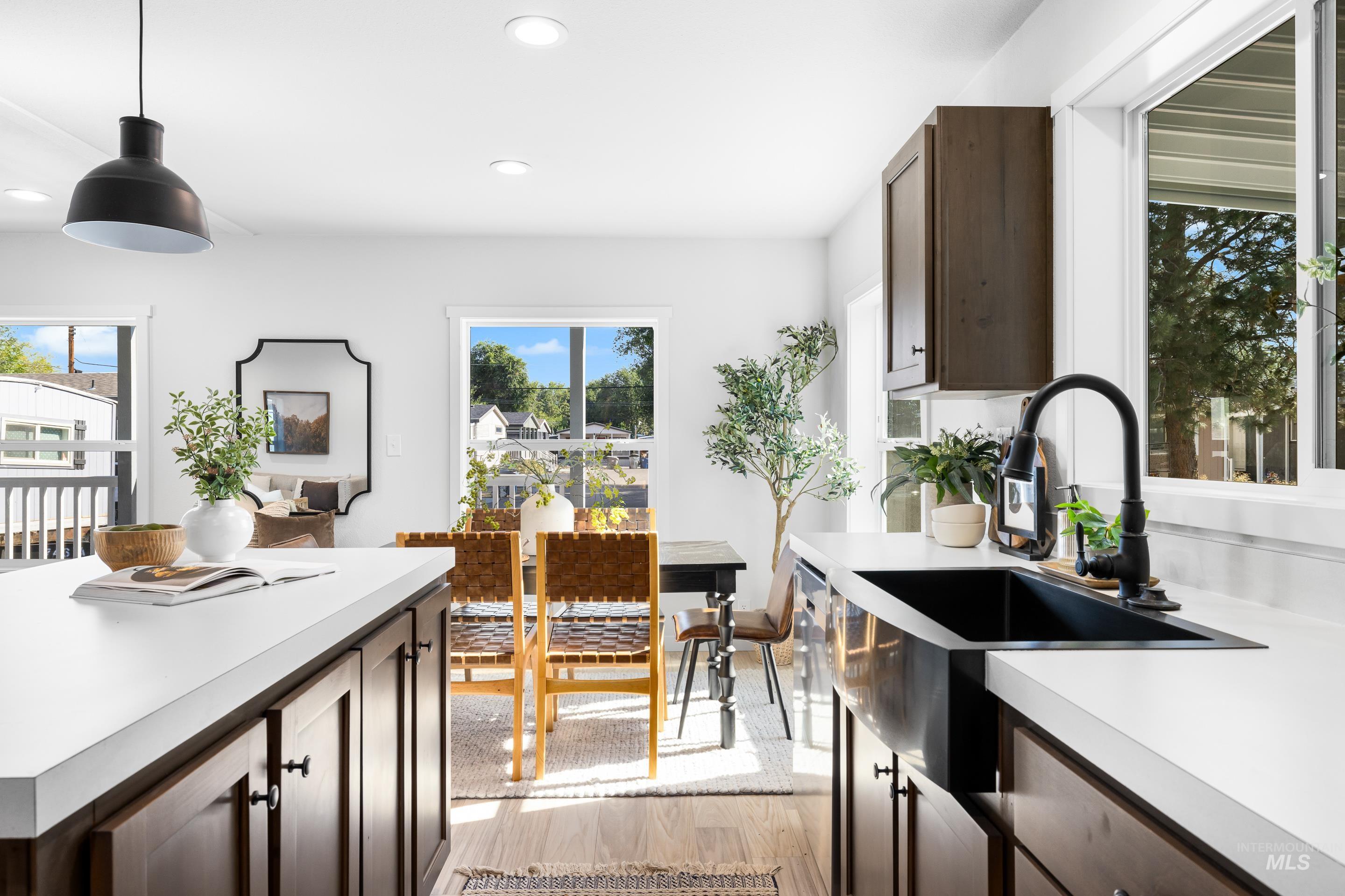 Kitchen featuring dark brown cabinets, light countertops, light wood finished floors, healthy amount of natural light, and recessed lighting