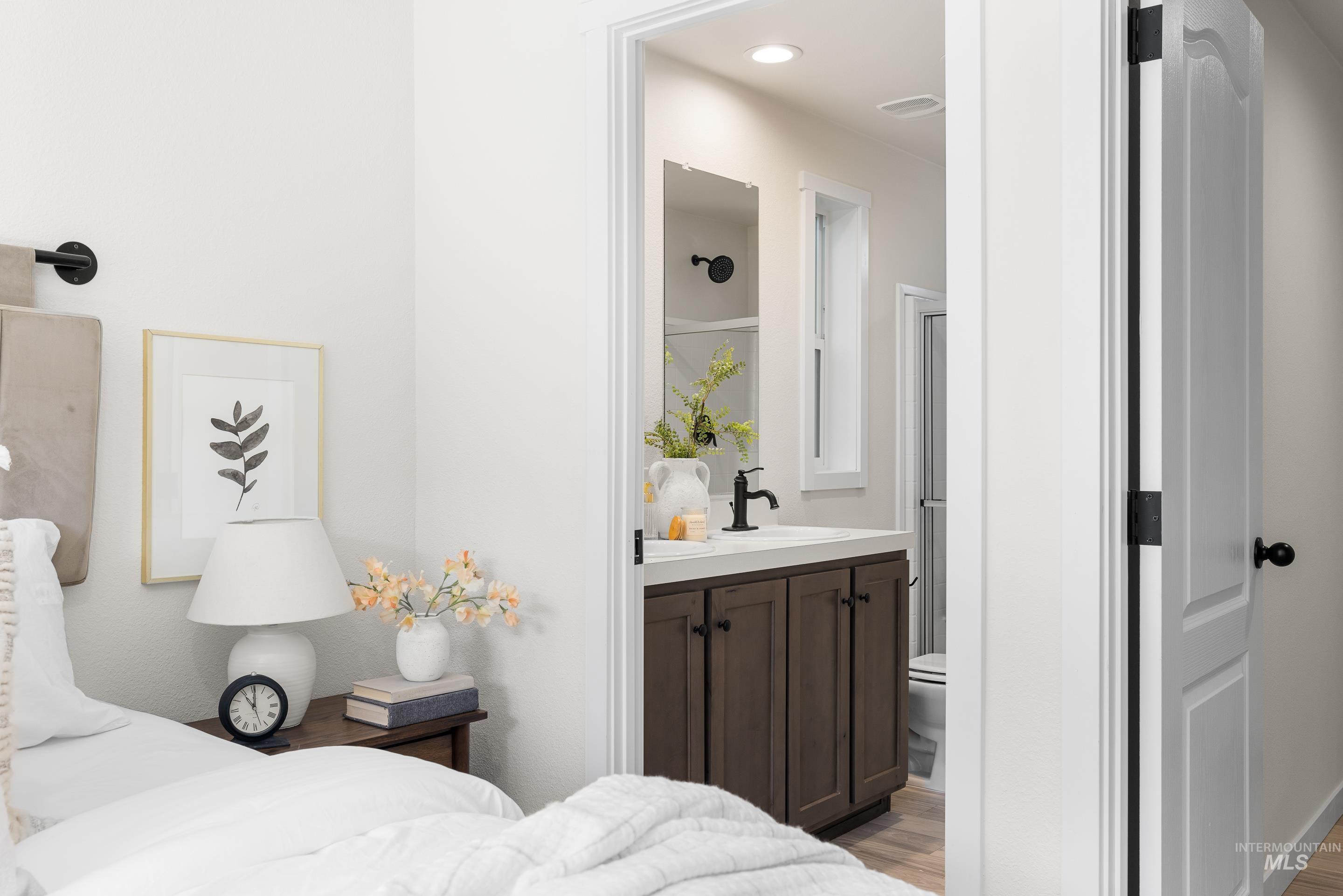 Bedroom featuring light wood-type flooring and ensuite bathroom