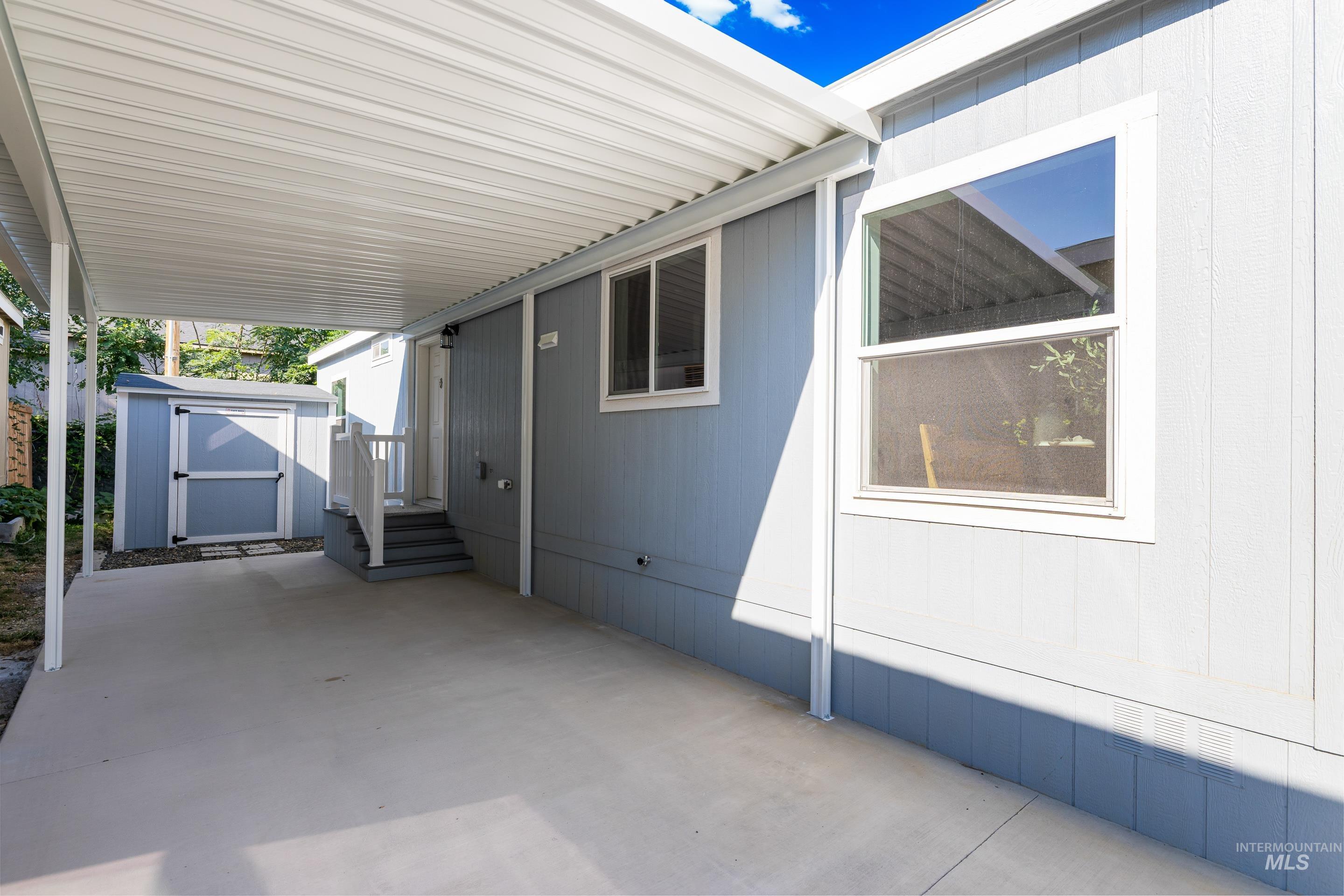 View of patio / terrace featuring a storage unit and a carport