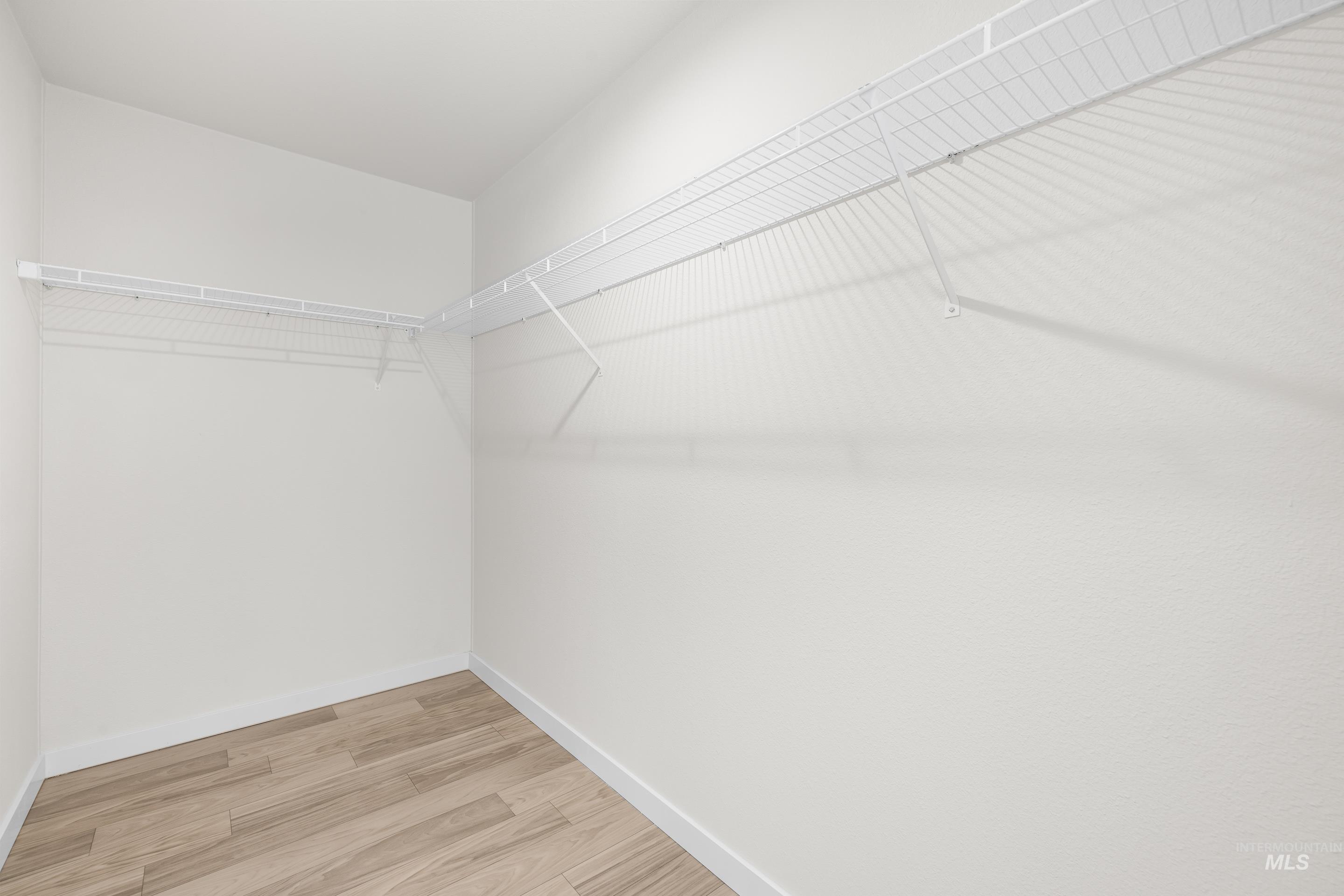 Walk in closet featuring wood finished floors