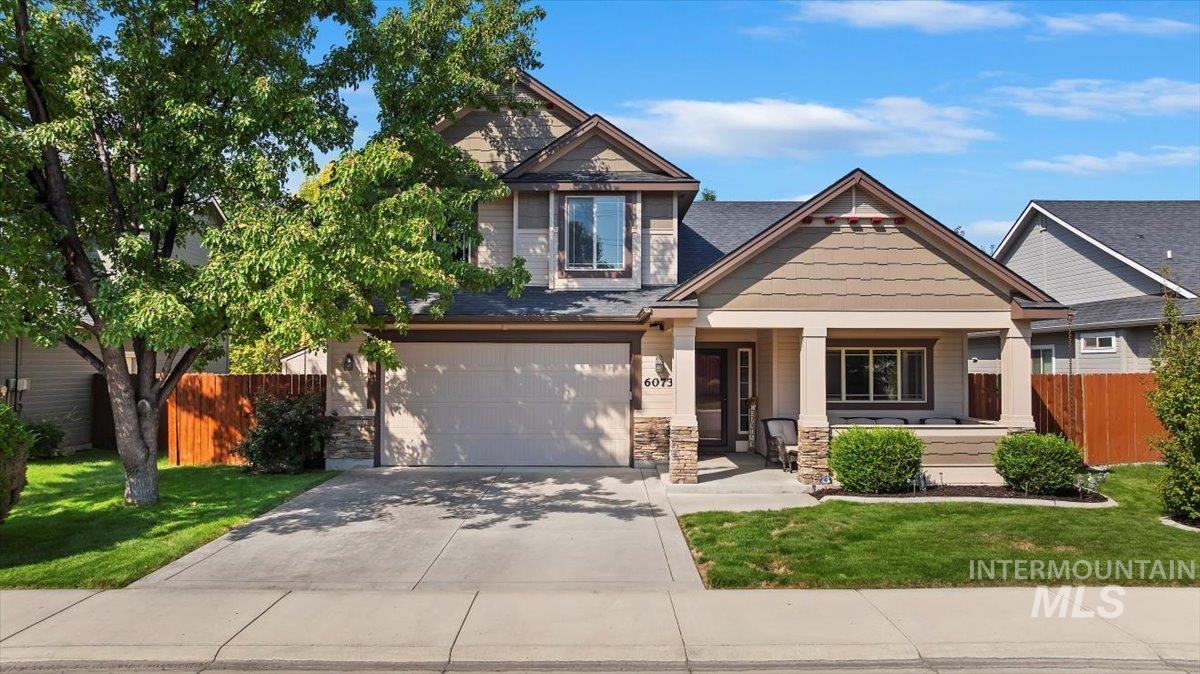 Craftsman house with a porch, concrete driveway, stone siding, and an attached garage