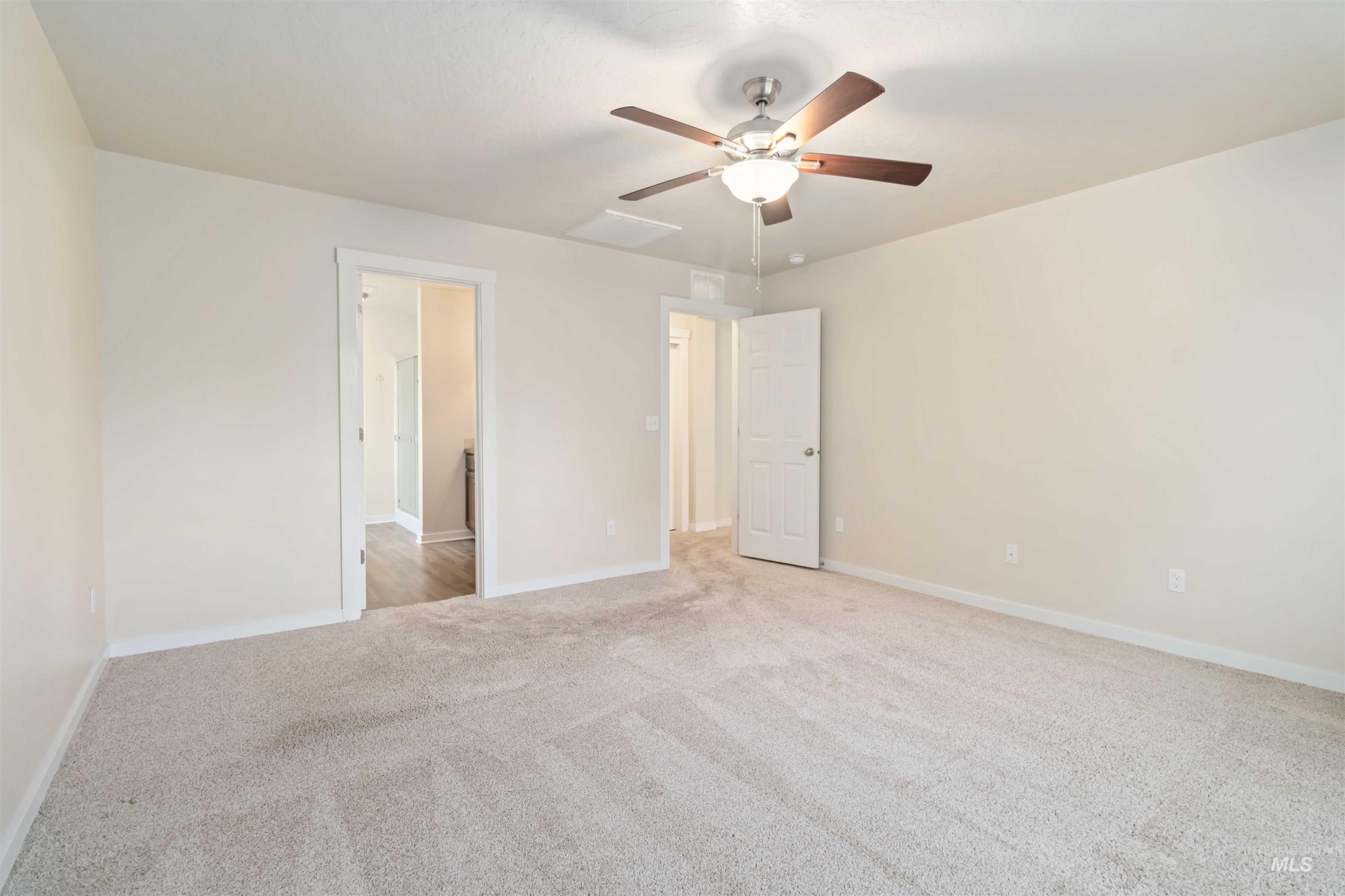 Unfurnished bedroom with light colored carpet and a ceiling fan
