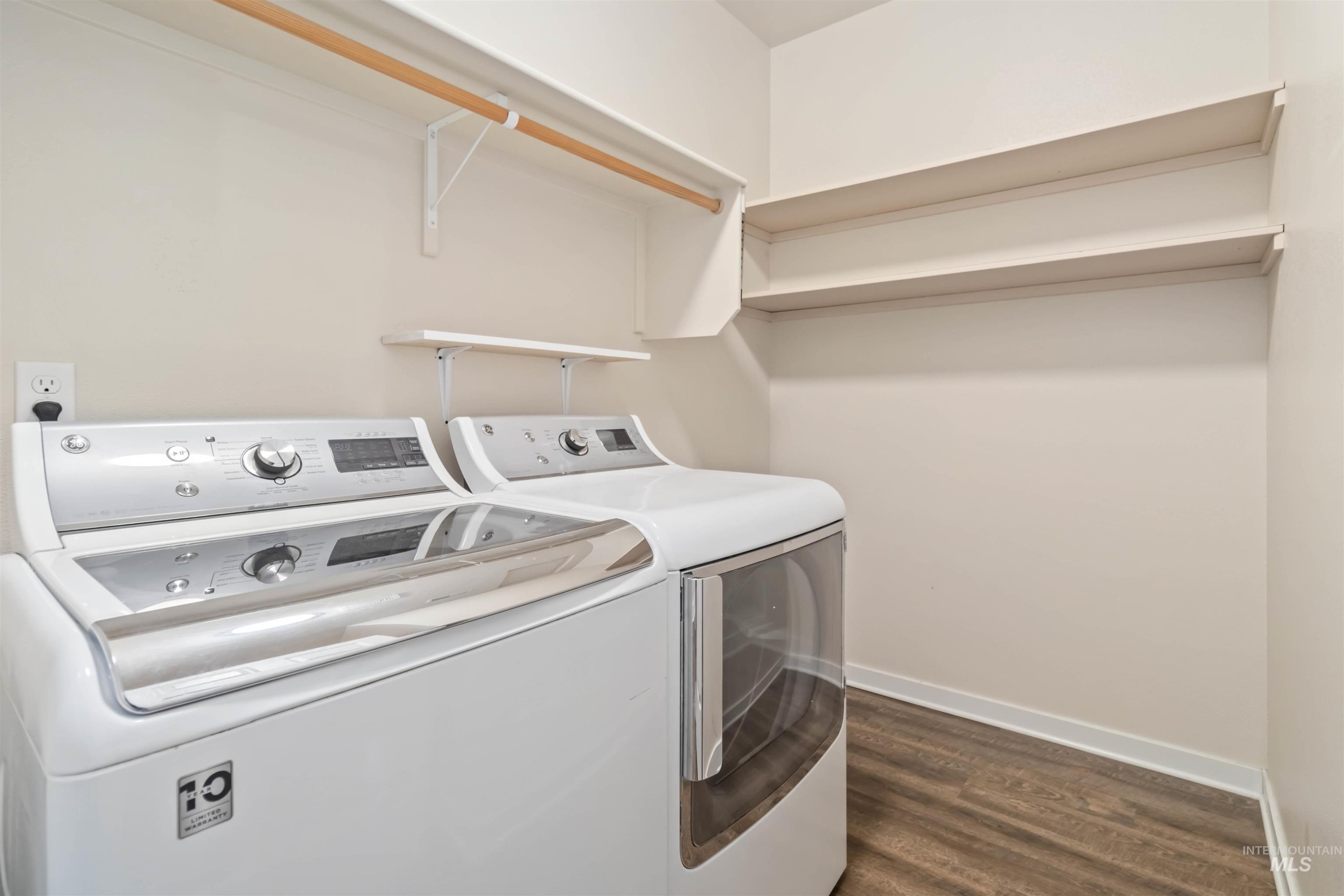 Washroom with dark wood finished floors and washer and clothes dryer