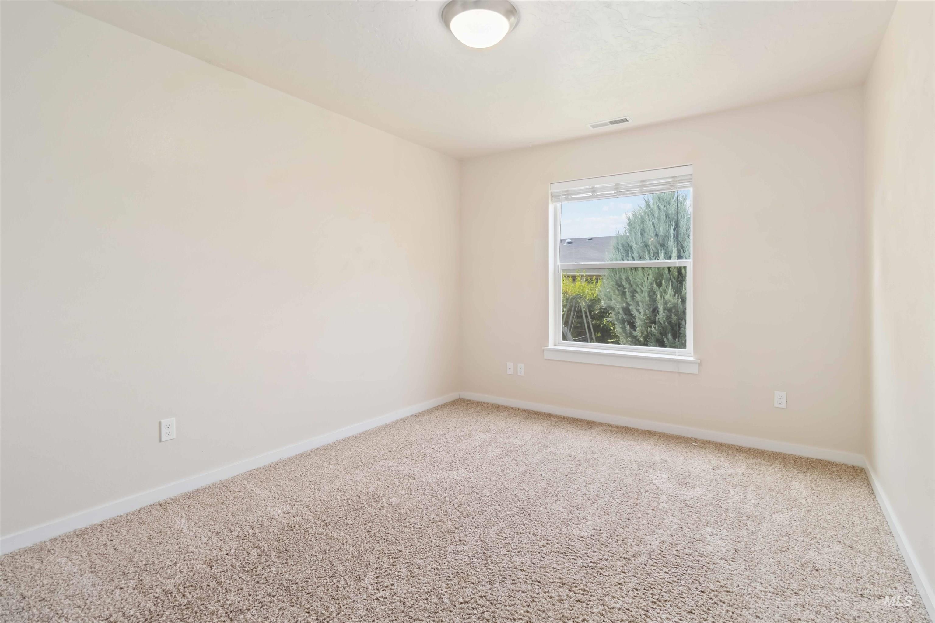 Carpeted empty room featuring baseboards