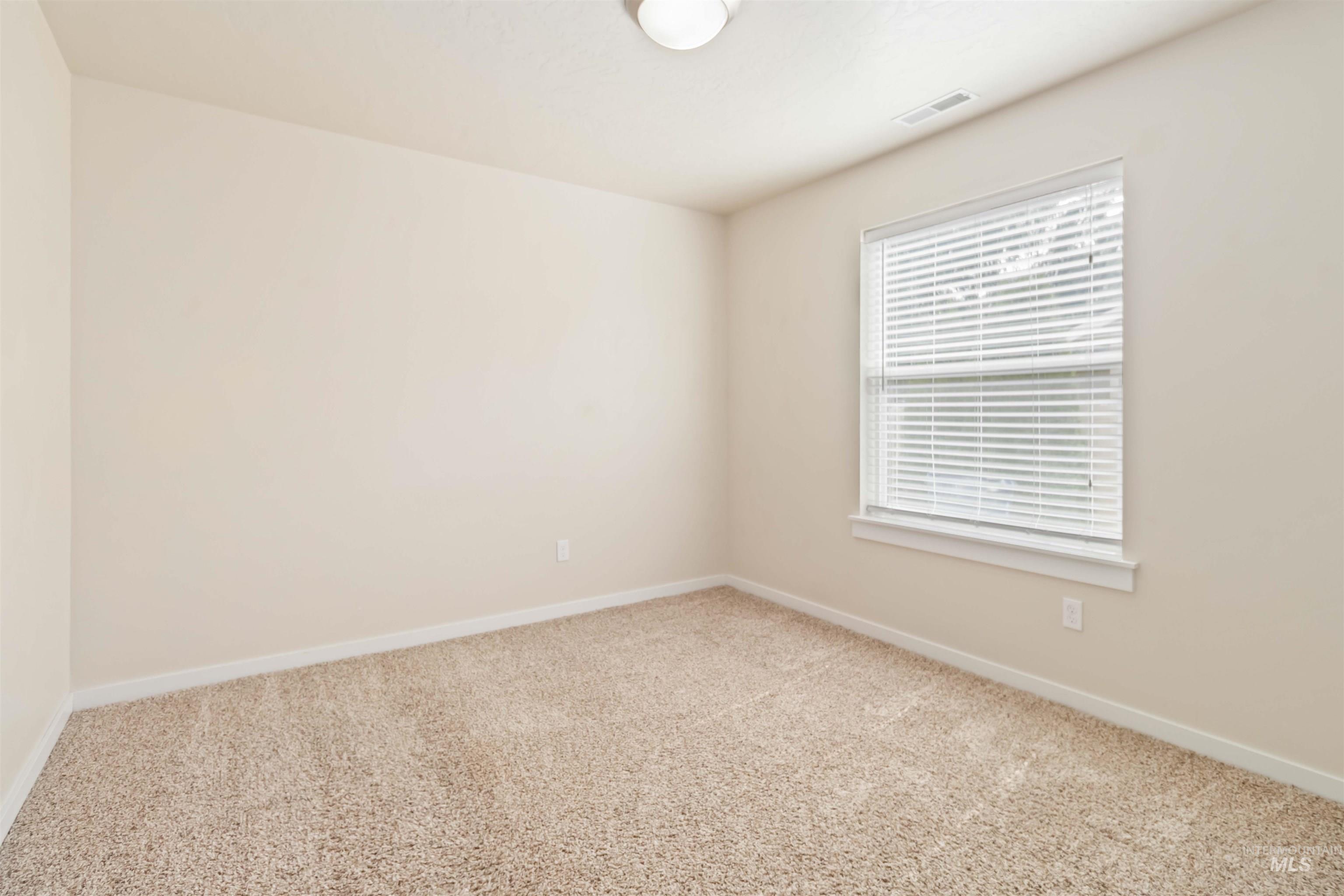 Carpeted empty room featuring baseboards
