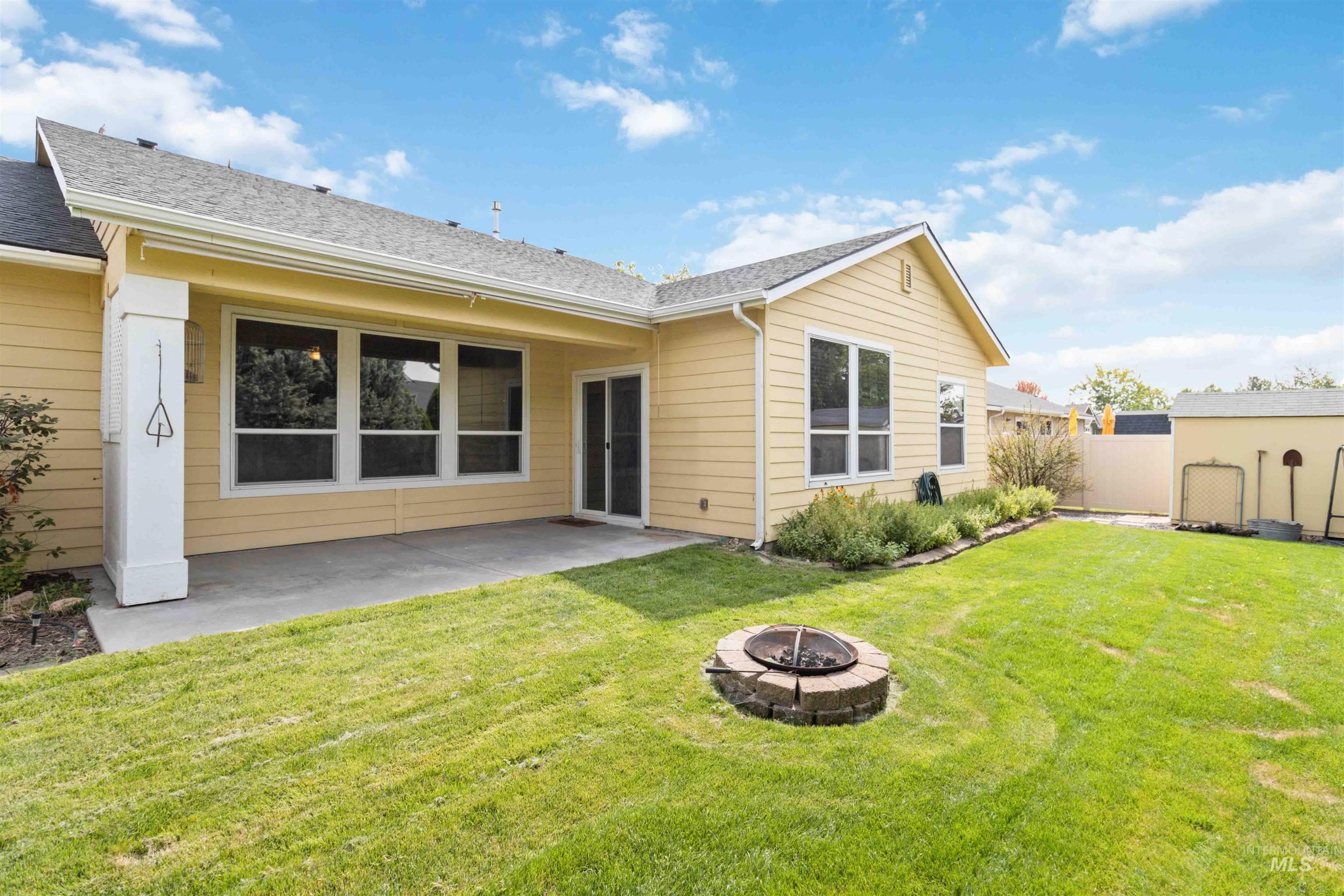 Rear view of property featuring a patio area, an outdoor fire pit, and roof with shingles