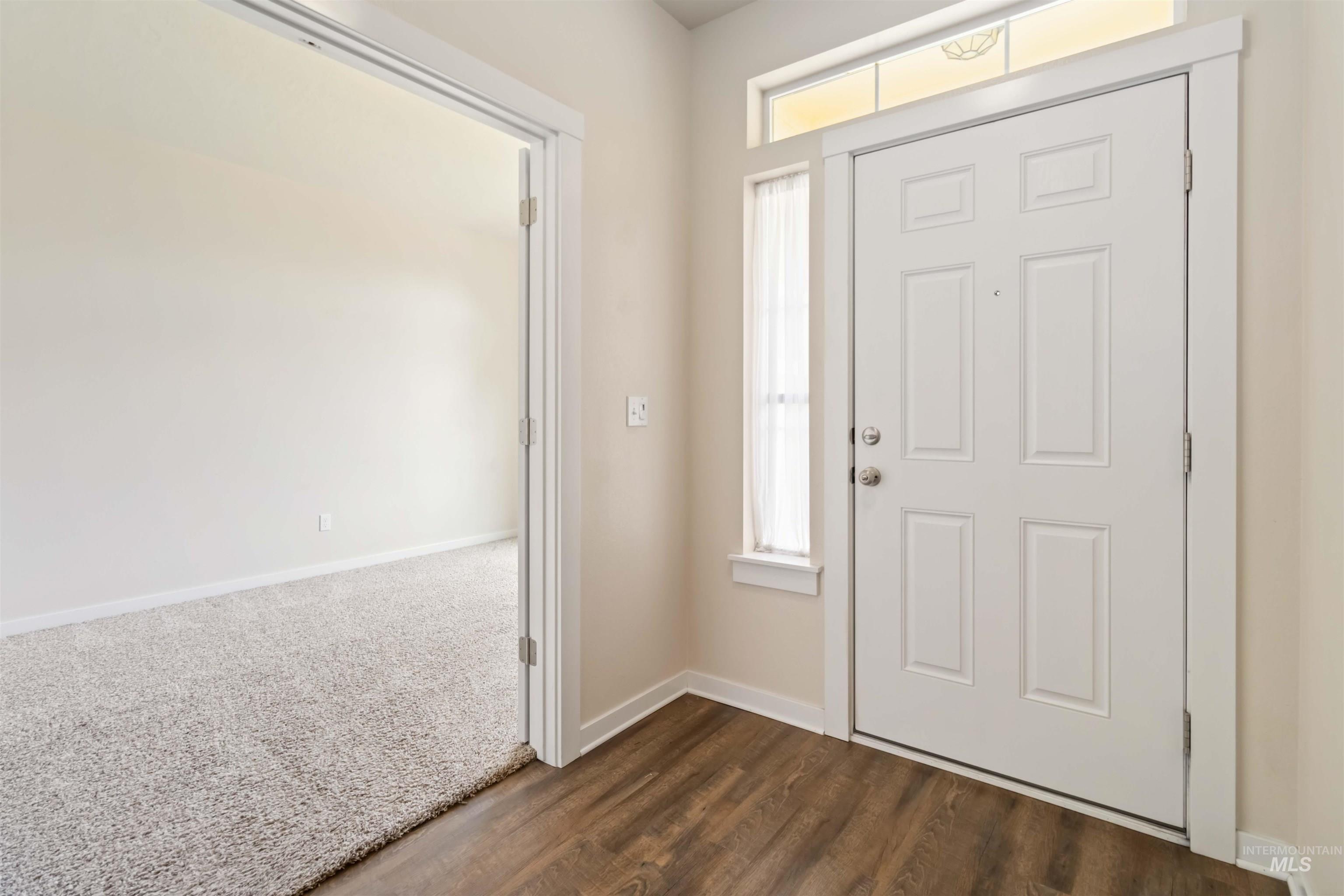 Foyer entrance with plenty of natural light and dark wood-style floors