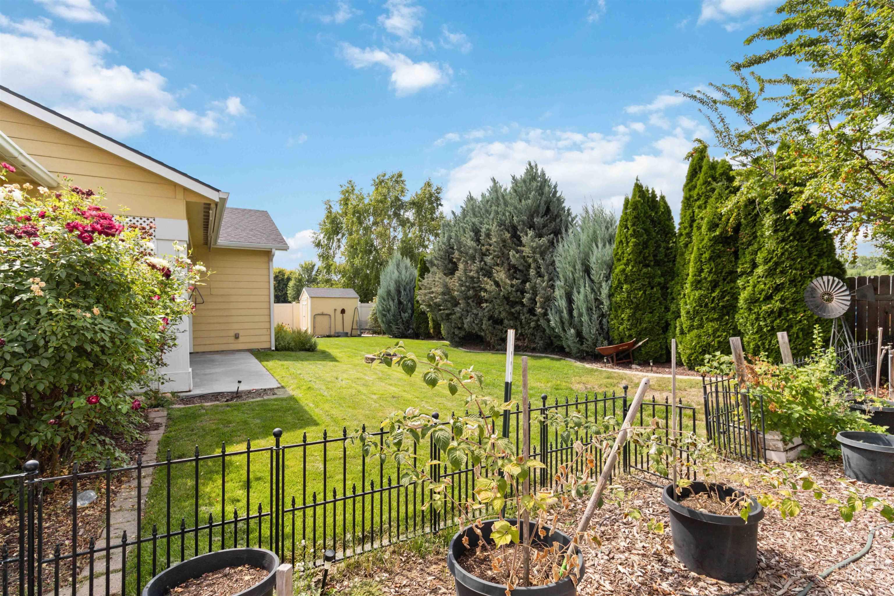 Fenced yard featuring a shed and a patio